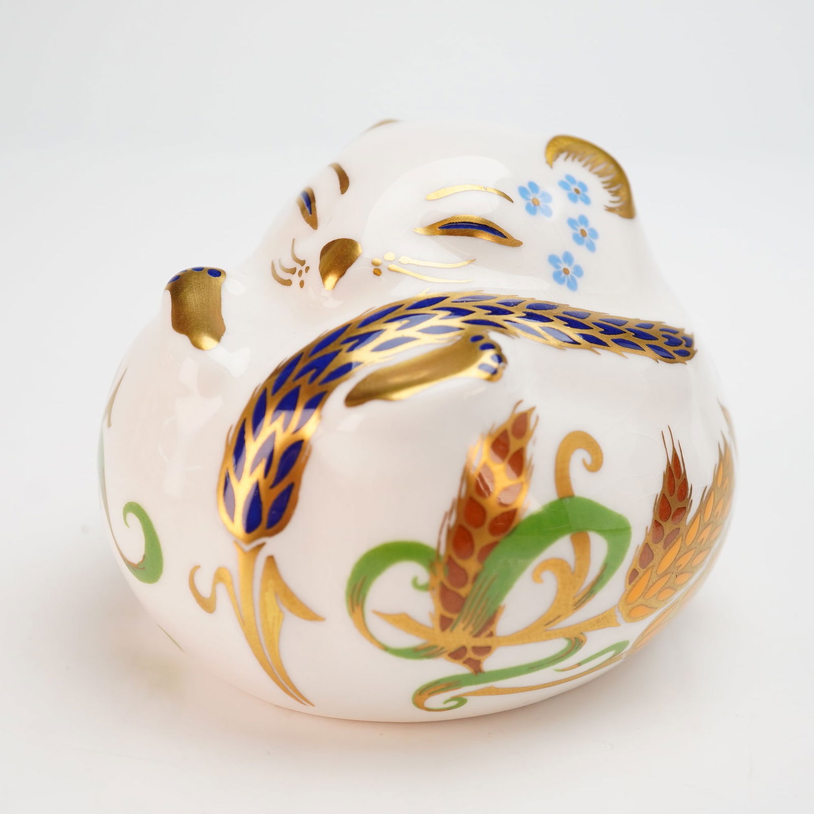 Royal Crown Derby Sleeping Dormouse Paperweight with Box: A Royal Crown Derby English fine bone china paperweight in the form of a sleeping dormouse. The figure is decorated in a stylized harvest-themed pattern, featuring hand-painted cobalt blue, iron red,