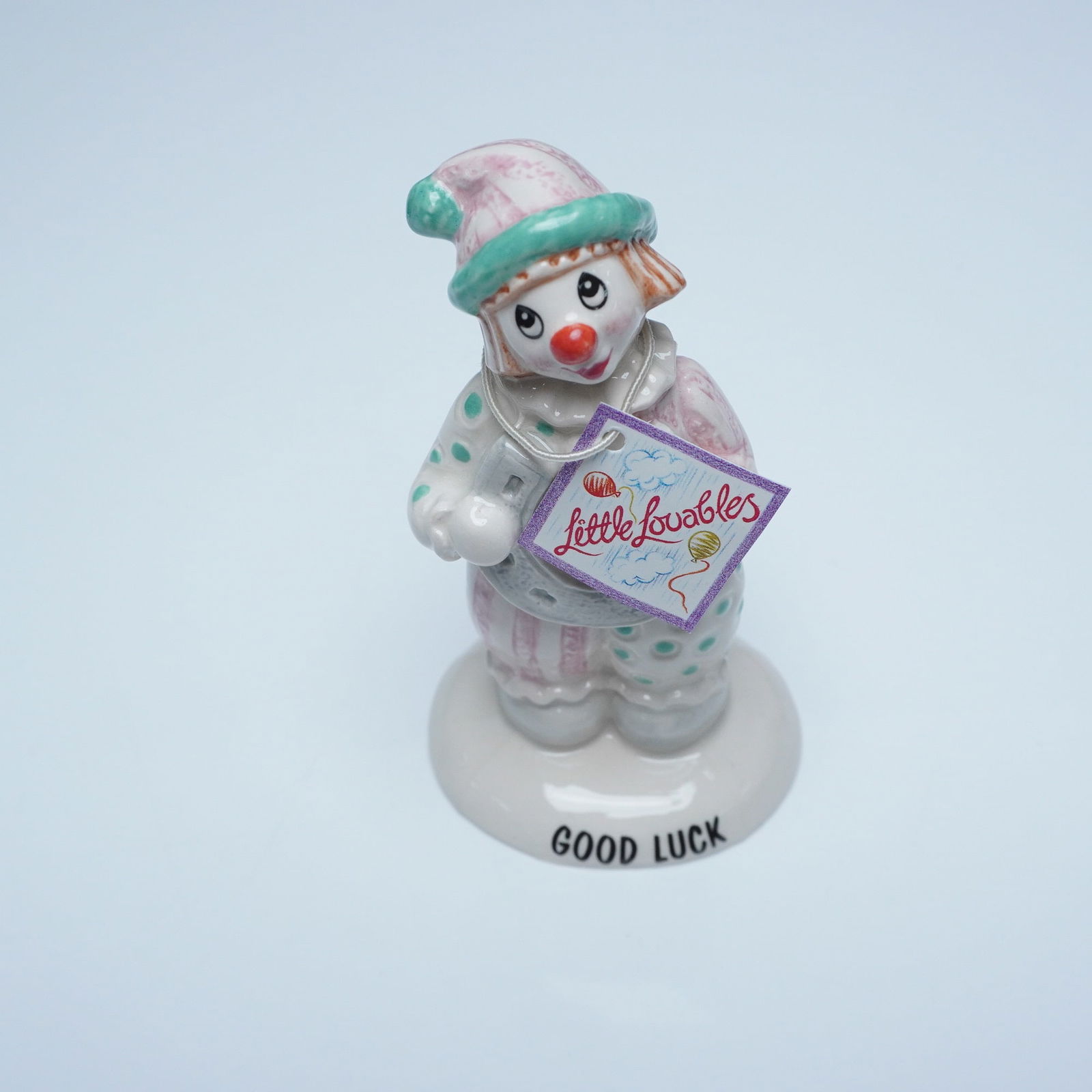 Beswick Little Lovables "Good Luck" Clown Figurine, LL31: A charming Beswick Little Lovables "Good Luck" clown figurine, model LL31. This hand-painted ceramic figure features a whimsical clown dressed in pastel pink and green polka-dotted attire, holding a l