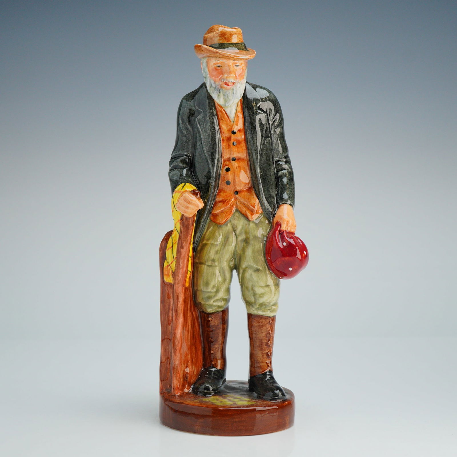 Royal Doulton Figurine The Gaffer HN2053: The piece depicts an elderly man with a white beard dressed in traditional rural attire, including a brown hat, an orange waistcoat, a dark olive-green overcoat, light green breeches, and tall brown b