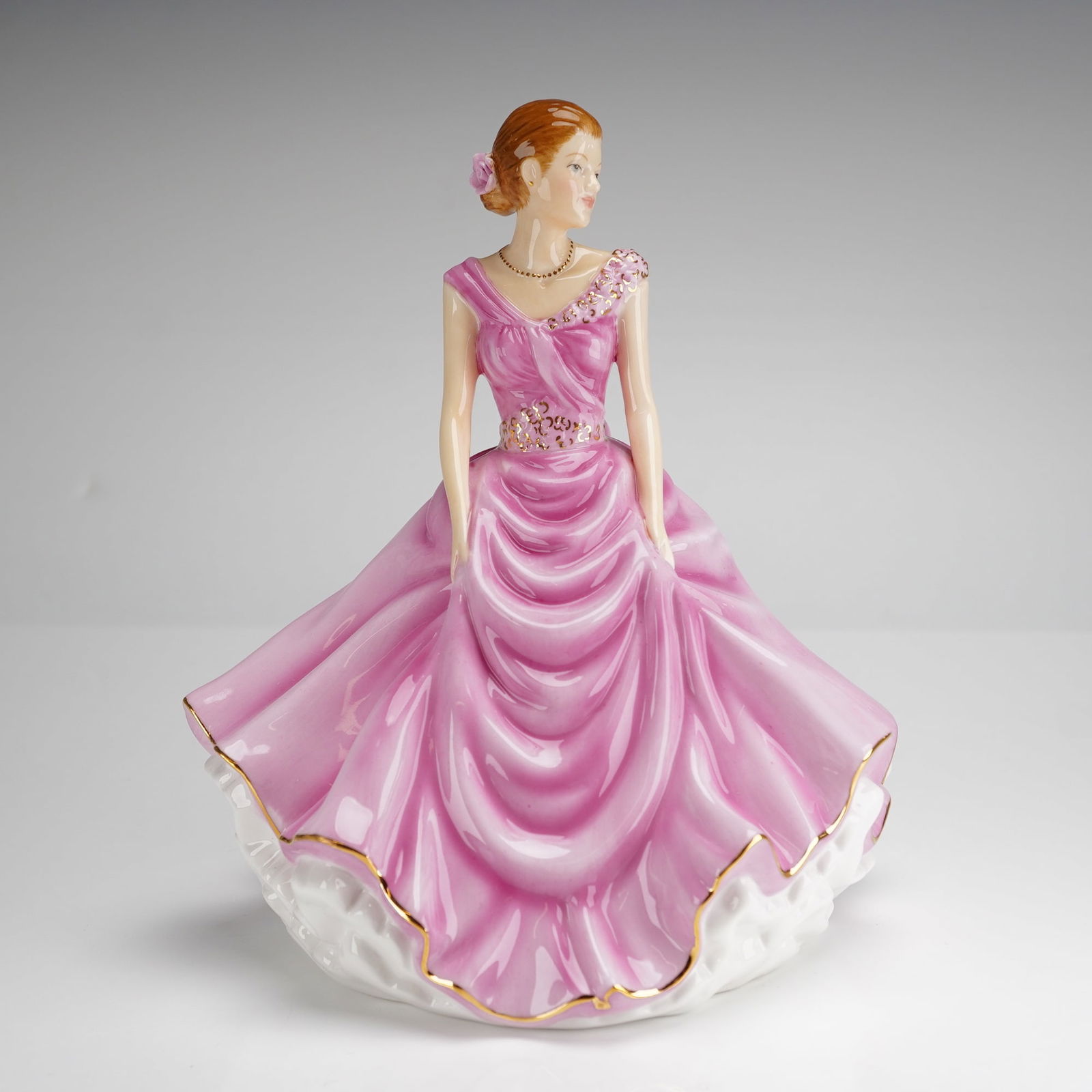 Royal Doulton Donna HN5590 Petite Figure of the Year 2013 Figurine: A Royal Doulton bone china figurine titled Donna, model number HN5590, from the Pretty Ladies collection. This piece is designated as the Petite Figure of the Year 2013 and was designed by Neil Faulkn