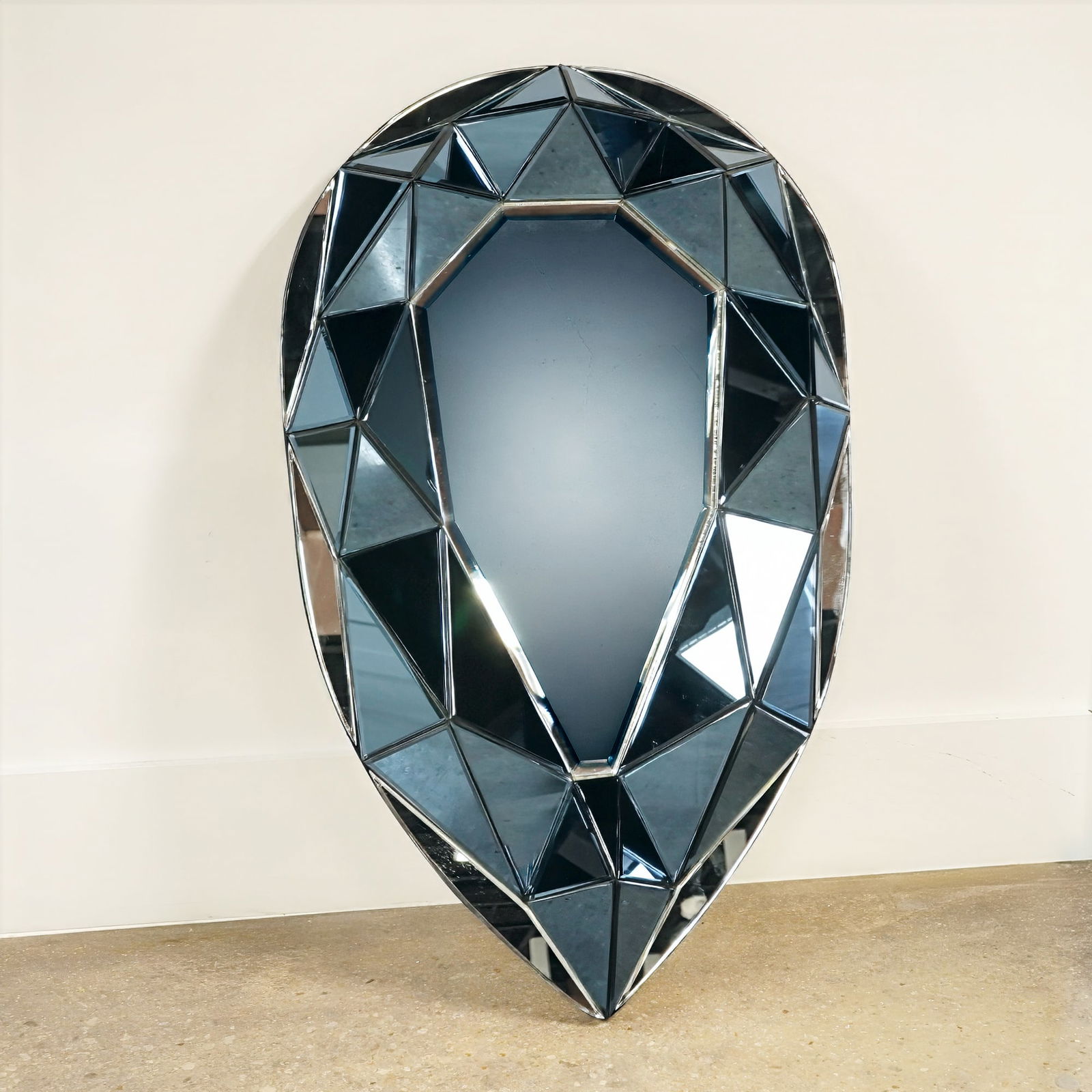 Olivier de Schrijver Dark Blue Diamond Mirror, Deep Blue Ocean: A wall-mounted decorative mirror titled Deep Blue Ocean by Belgian designer Olivier de Schrijver. The piece is designed in the form of a large, faceted pear-cut gemstone, featuring multiple triangular