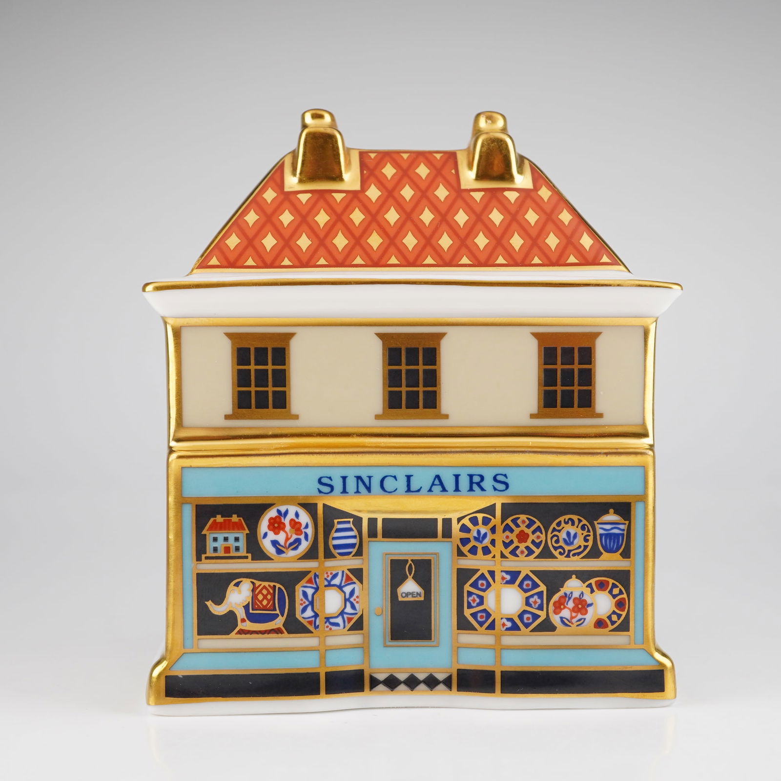 Royal Crown Derby Miniature House Bone China Paperweight: The Royal Crown Derby "The China Shop" is a fine bone china paperweight that was the first building introduced in the general range of miniature village buildings in July 2001. Modelled by Mark Delf,