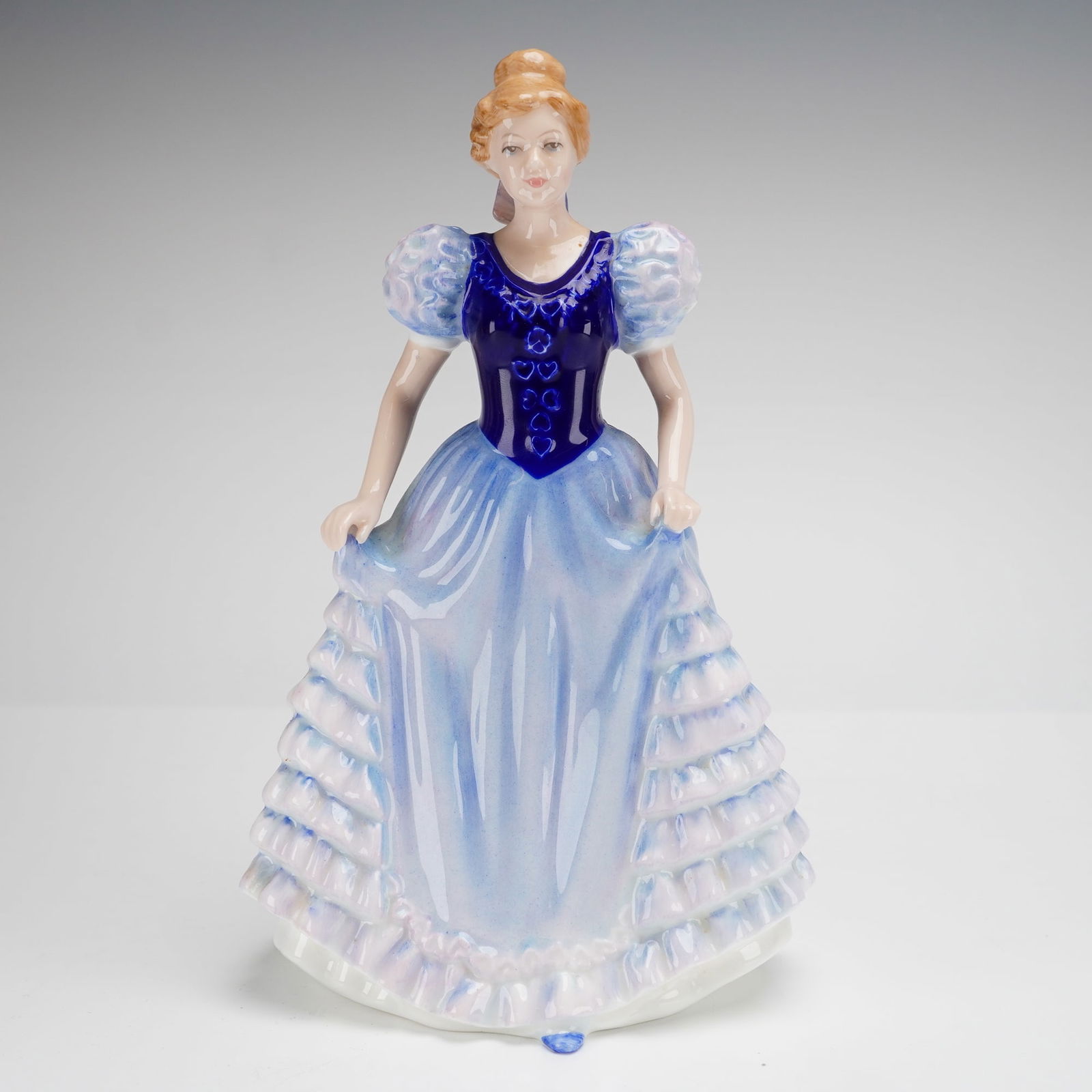 Royal Doulton Bone China Figurine Charlotte HN 3658: A Royal Doulton glazed bone china figurine titled Charlotte, model number HN 3658, modeled by Nada M. Pedley and dated 1994. The figure is depicted in a Victorian-style gown featuring a deep cobalt bl