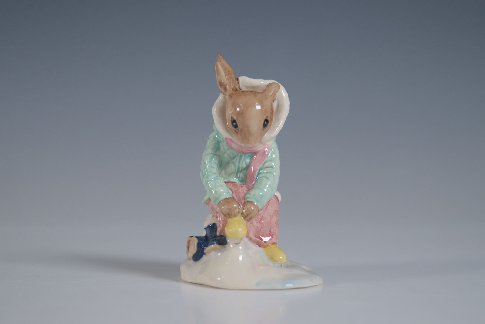 Royal Doulton Bunnykins Figurine, Girl Skater DB153: This delightful Royal Doulton Bunnykins figurine, titled "Girl Skater Bunnykins" (DB153), depicts a bunny dressed in a charming winter outfit, skating gracefully. The figurine stands 3.5"H and is in e