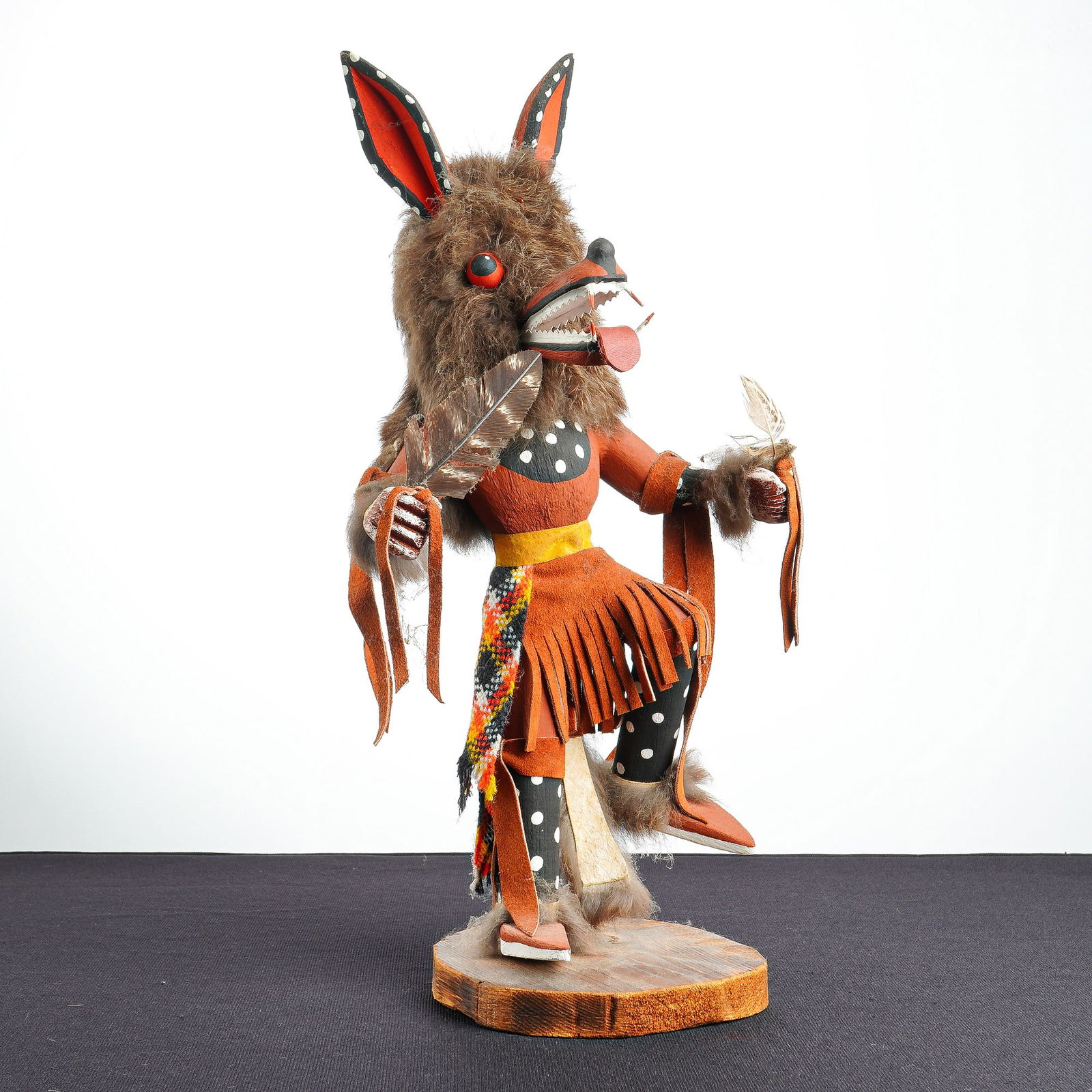 Native American Kachina Doll, The Wolf Man Kachina: This hand-carved and painted wooden Wolf Man Kachina doll is depicted in a dynamic dancing pose and features mixed-media construction including a brown fur-covered head and back, red eyes, and a