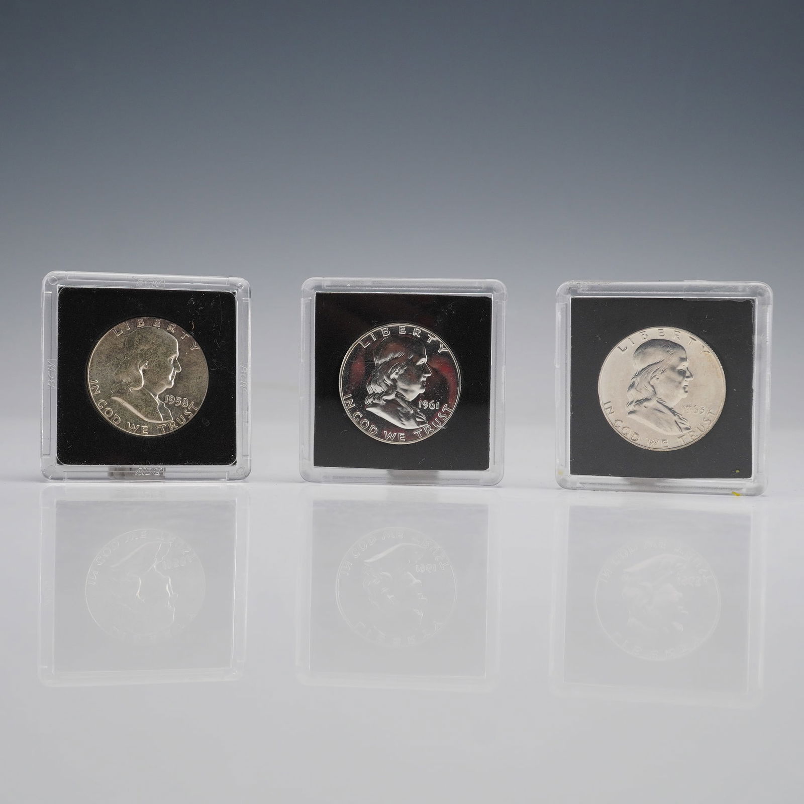 US Franklin Half Dollar Trio, 1958, 1961, 1963: A trio of US Franklin Half Dollars, comprising the dates 1958, 1961, 1963. All three pieces are presented in individual square plastic displays. The design features the Franklin Obverse and Liberty