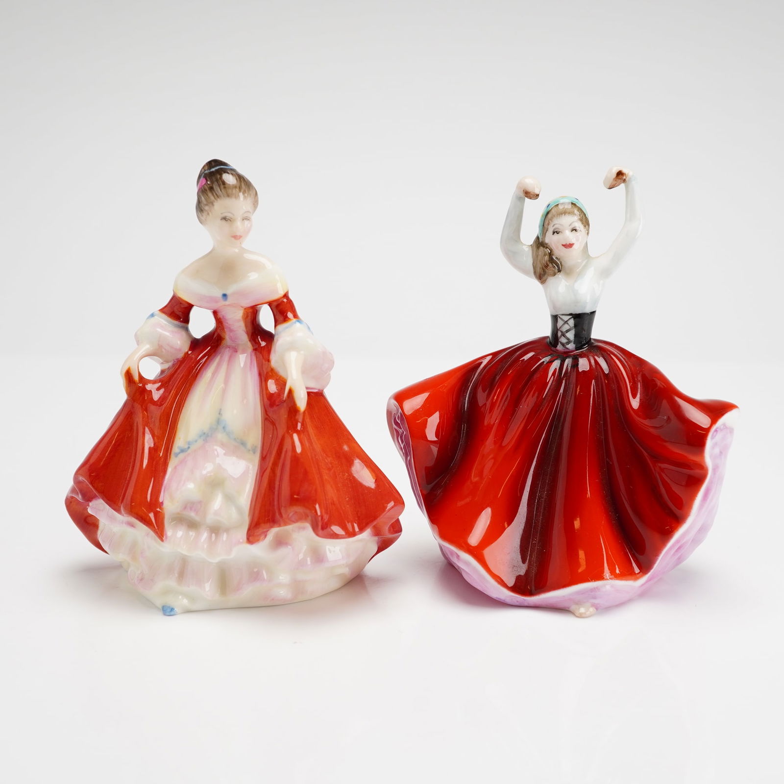 Two Royal Doulton Mini Figurines Southern Belle HN3174 & Karen HN3270: Designed by Peggy Davies, these hand-painted bone china figures feature a high-gloss finish. Southern Belle is modeled in a red off-the-shoulder gown with a tiered pink and white underskirt. Karen is