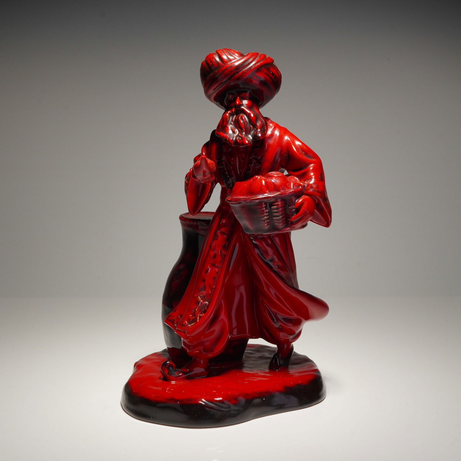 Royal Doulton Flambe Porcelain Figurine, The Lamp Seller HN3278: A Royal Doulton Flambe porcelain figurine titled The Lamp Seller, model number HN3278. This piece was modeled by Robert Tabbenor and depicts a bearded figure in traditional attire, including a large