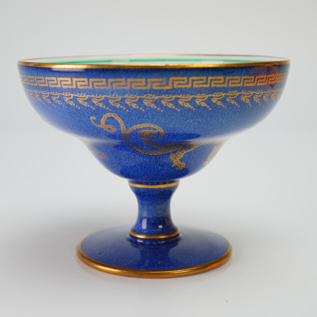 Wedgwood Fairyland Lustre Melba Cup, Dragons Z4616: Designed by Daisy Makeig-Jones (British, 1881-1945). The small footed cup features an exterior finished in powder blue (bleu souffle) decorated with small gilt dragons encircling the bowl and a Greek