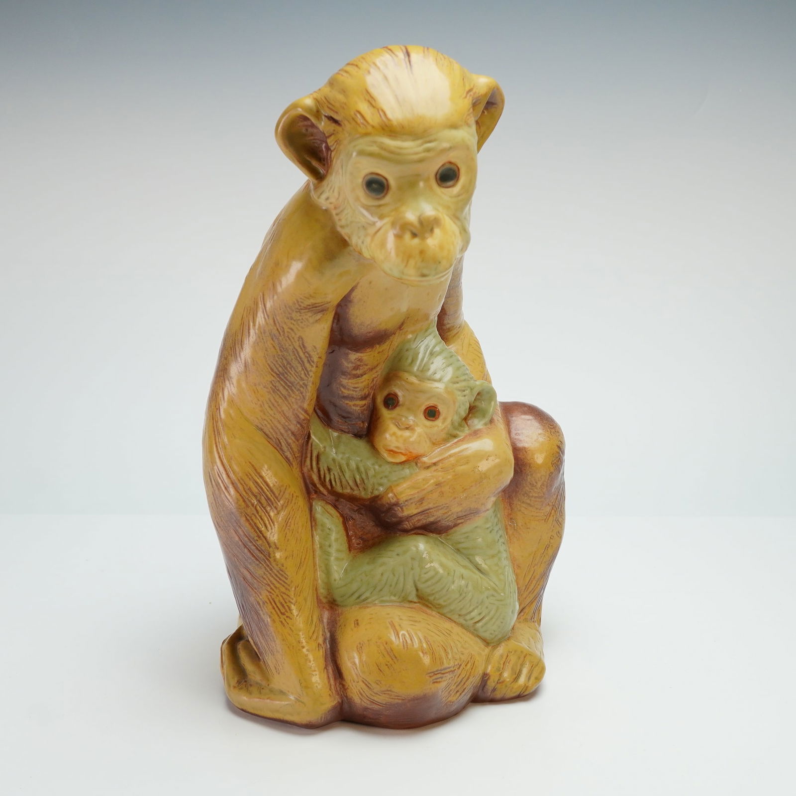 Lladro Gres Porcelain Sculpture, Monkey 01012000: This porcelain piece depicts a mother monkey in a seated, naturalistic pose cradling her infant. The figurine features textured fur detailing and is finished in a polychrome gloss glaze of ochre, sien