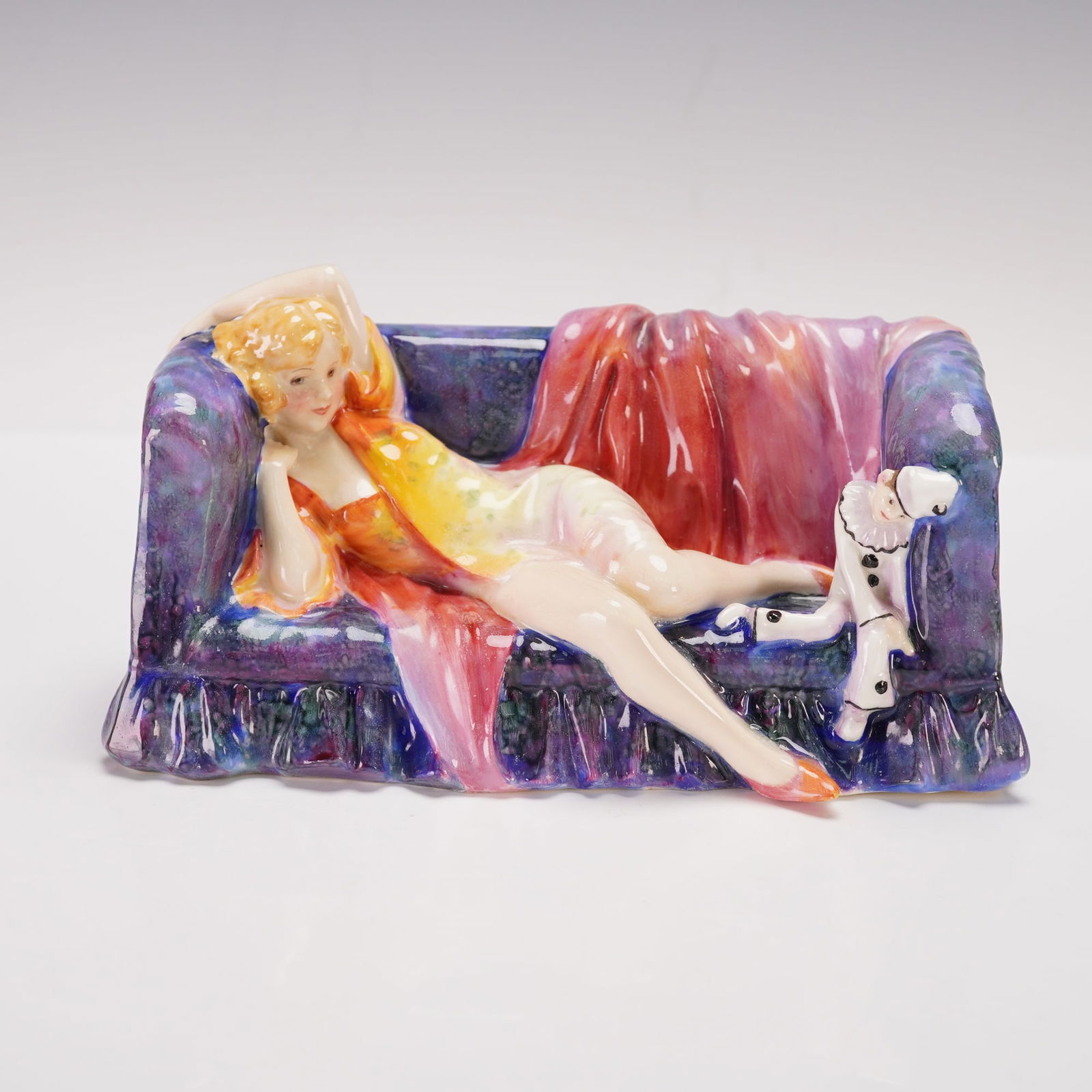 Royal Doulton Colorway Figurine, Dreamland HN1481: Exquisite Royal Doulton Dreamland HN1481 colorway figurine, designed by the renowned Leslie Harradine. This rare and beautifully detailed piece features a reclining lady on a plush sofa, dressed in a