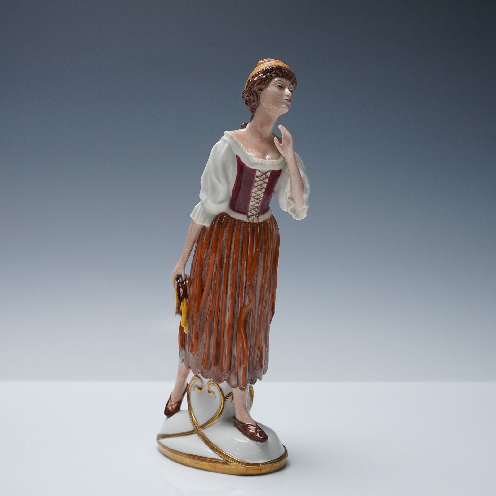 Royal Doulton Prototype Elsie Maynard figurine: Royal Doulton bone china prototype figurine depicting Elsie Maynard as a standing woman holding a tambourine in one hand. The figure is dressed in a traditional costume composed of a white blouse,