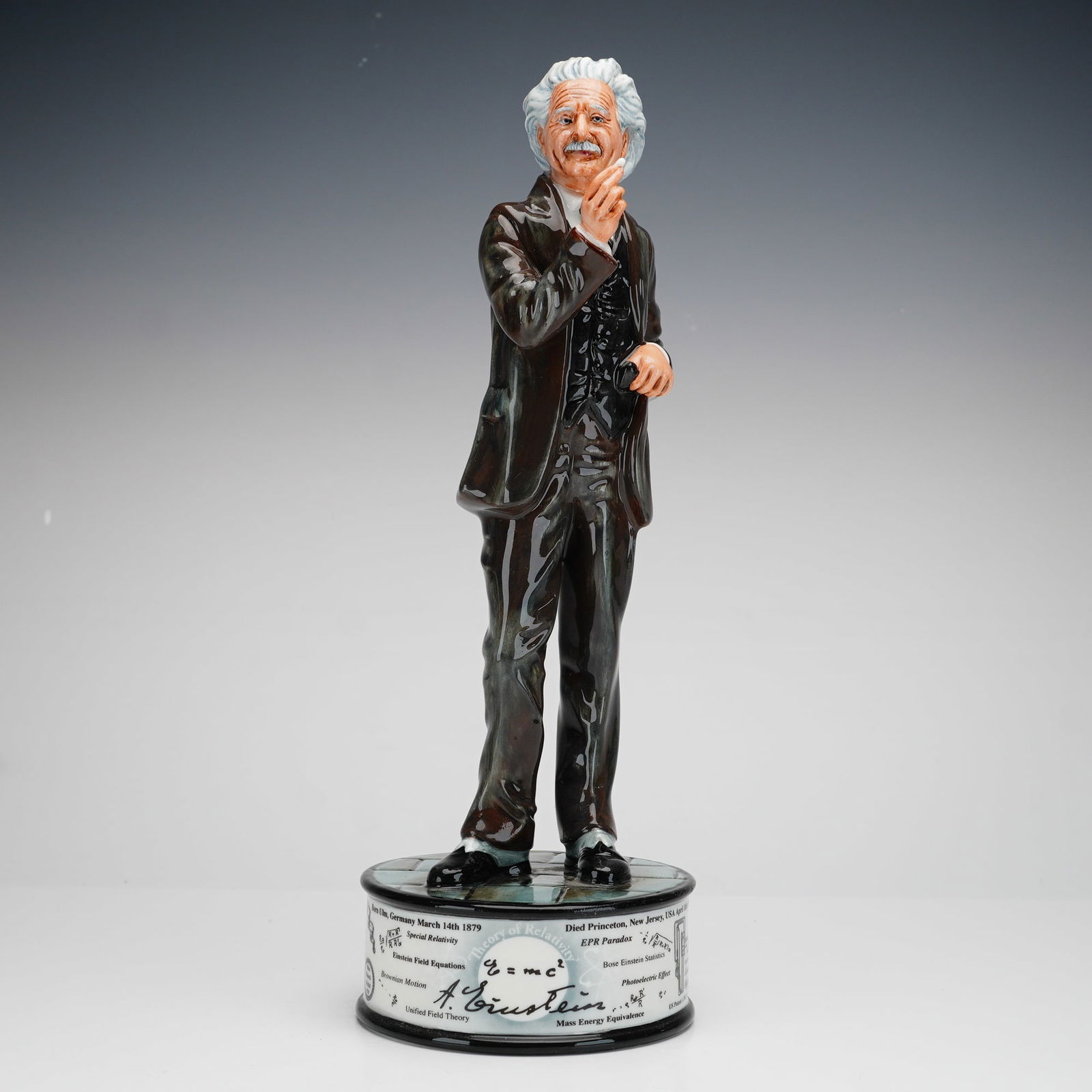 Royal Doulton Figurine, Albert Einstein HN5240: This hand-painted, limited edition 75 of 250, fine bone china figure depicts Einstein in a three-piece suit holding a pipe, standing on a circular plinth base. The base is decorated with graphics and