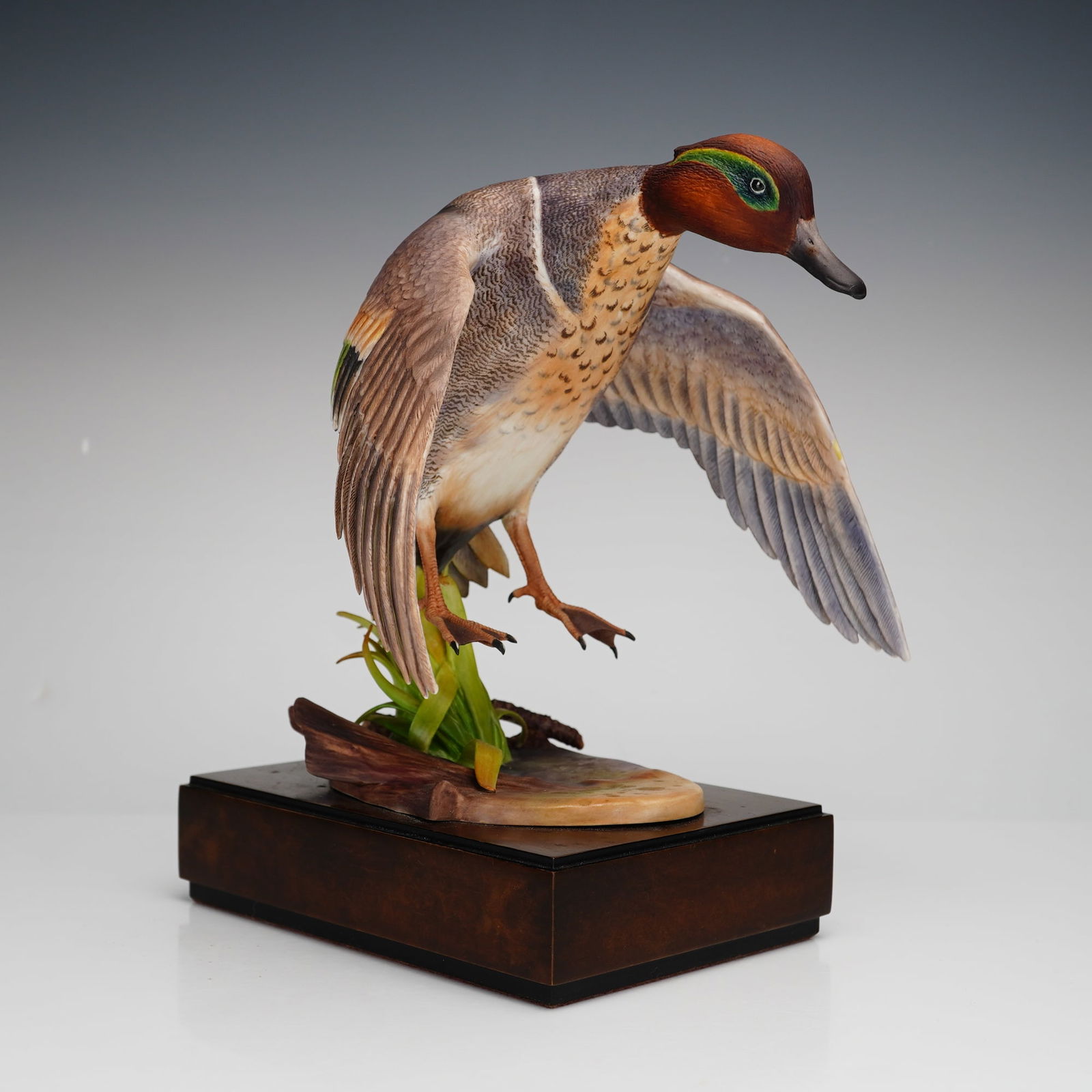 Royal Worcester Ronald Van Ruyckevelt Figurine, Green-Winged Teal: Bone china figurine depicting a green-winged teal in flight, designed by Ronald Van Ruyckevelt. This naturalistic sculpture captures the duck mid-air with extended wings and detailed plumage. Marked o
