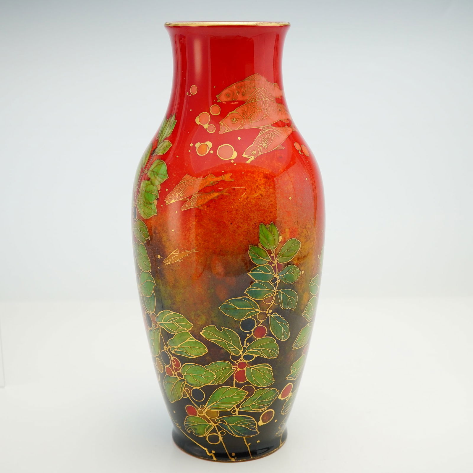 Royal Doulton by Harry Nixon Flambe Underwater Scene Fish Vase: Designed by Harry Nixon, this flambe red vase is decorated with an underwater scene featuring various fish in dark pink and salmon tones swimming through seaweed, with round red and dark red sea grape