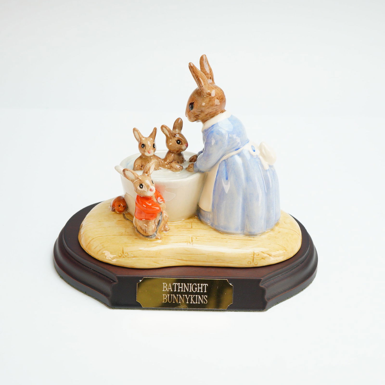 Royal Doulton Bunnykins Tableau, Bathnight Bunnykins DB241 with Base & COA: This hand-made and hand-decorated porcelain figurine tableau depicts an anthropomorphic scene of a mother rabbit in a blue dress and white apron bathing several smaller rabbits in a white tub. The fig