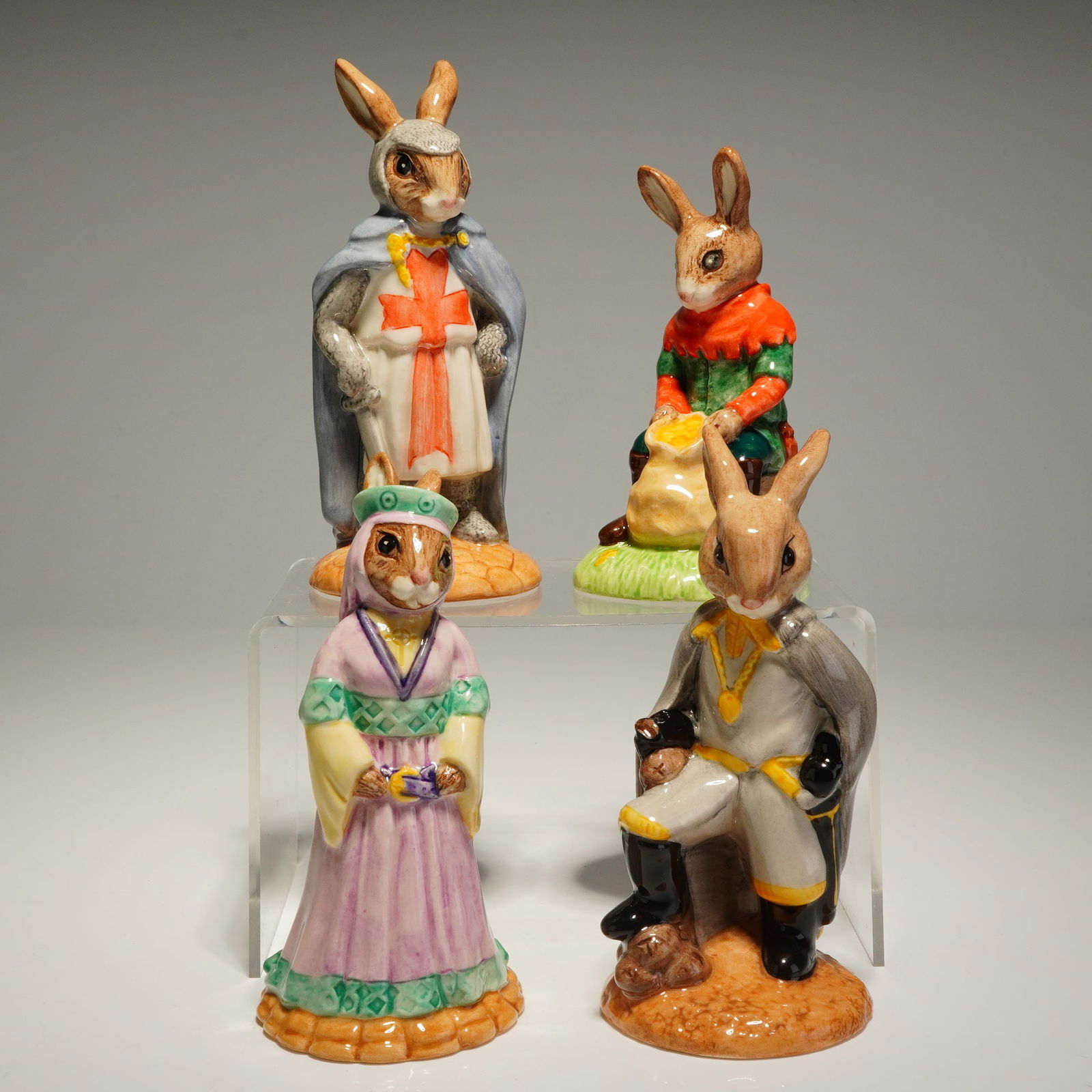 4pc Royal Doulton Robin Hood Bunnykins Figurines: A collection of Royal Doulton Bunnykins glazed porcelain figurines from The Robin Hood Collection. This set includes four hand-decorated anthropomorphic figures: King Richard (DB 258) wearing a crusad