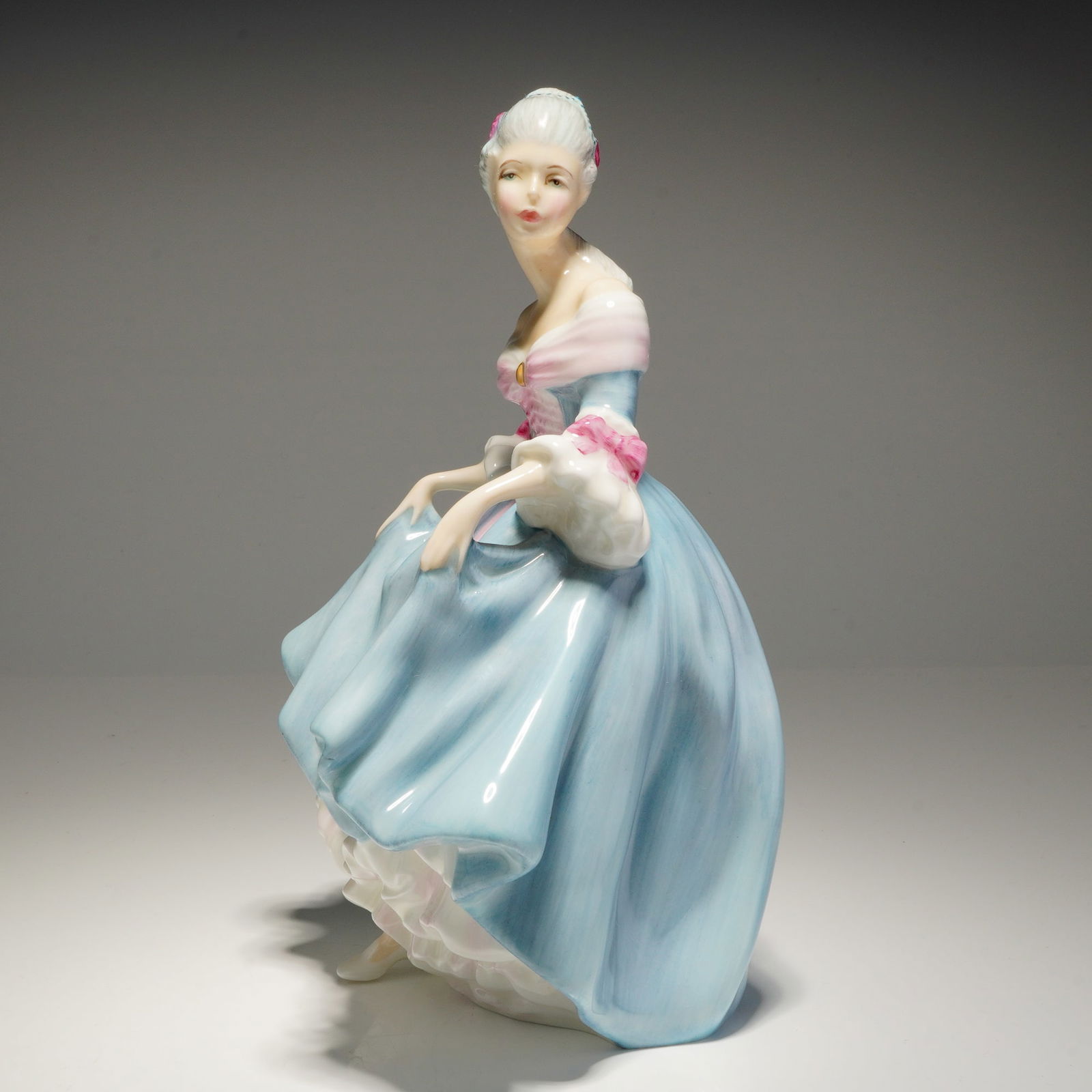 Royal Doulton Figurine Southern Belle HN 2425: A single Royal Doulton porcelain figurine, Southern Belle HN2425, featuring a woman in a light blue and pink dress, modelled by Peggy Davies and copyrighted 1957. Dimensions: 6.00"L x 4.25"W x 8.00"H