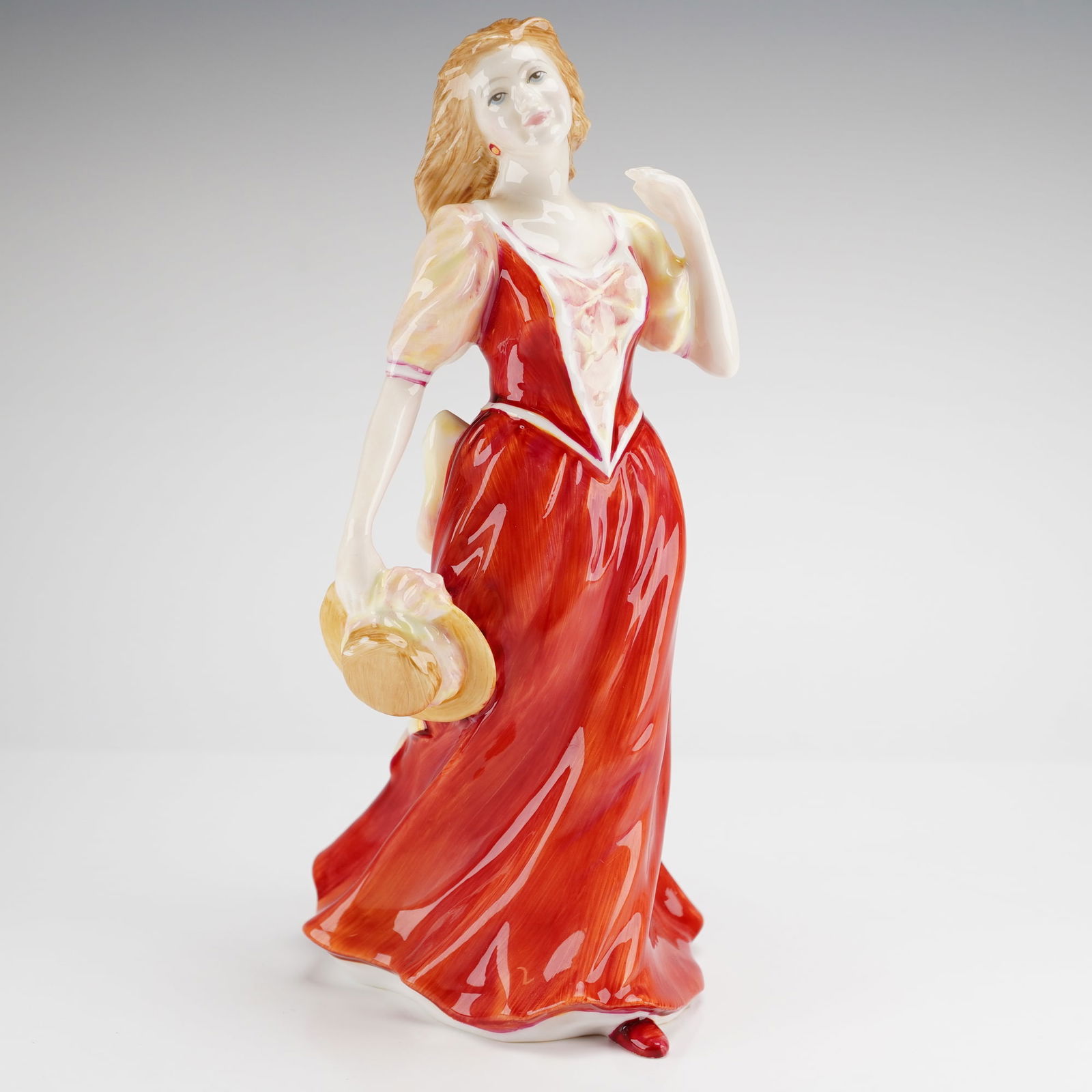 Royal Doulton Figurine, Strolling HN 3755: A single Royal Doulton Figurine, Strolling HN3755, depicting a woman in a red dress holding a straw hat, marked Royal Doulton Inc., modeled by Tim Potts, and copyrighted 1995. Dimensions: 4.00"L x 3.5