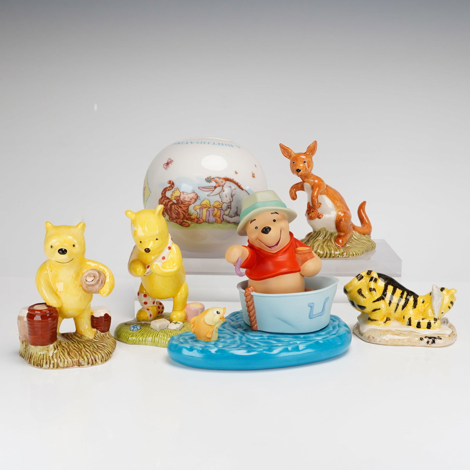 6pc Royal Doulton Winnie the Pooh Figurines & Coin Bank: This 6pc collection of Winnie the Pooh figurines and a coin bank features several hand-painted glazed ceramic pieces from the Royal Doulton Winnie the Pooh Collection. The group includes specific mode