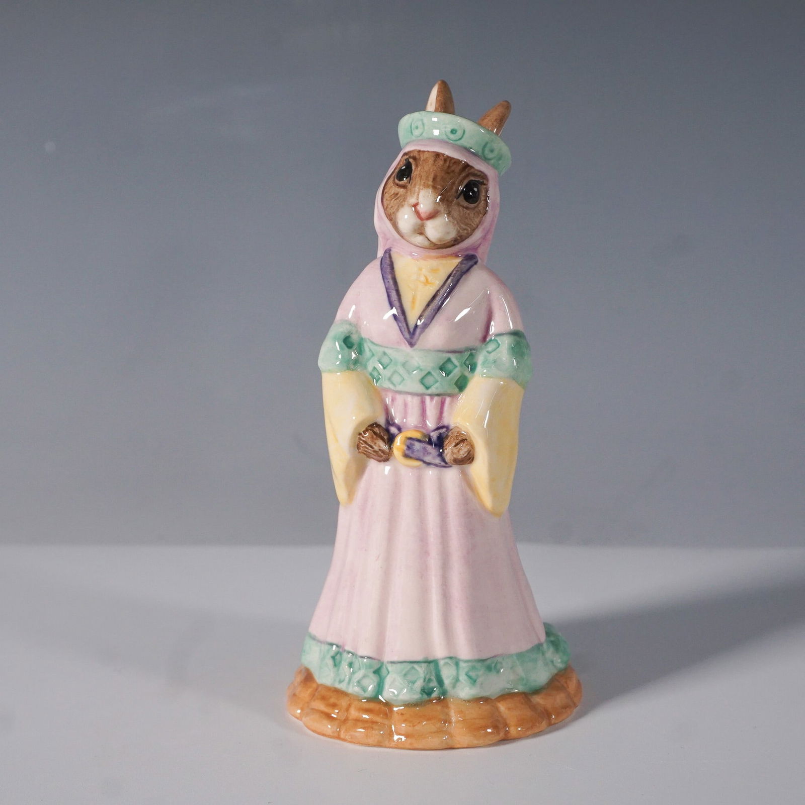 Royal Doulton Bunnykins Figurine, Maid Marion DB245: This Royal Doulton Bunnykins figurine, Maid Marion DB245, is part of the Robin Hood Collection. Handcrafted from fine bone china, this charming piece depicts Maid Marion in a flowing pink gown with gr