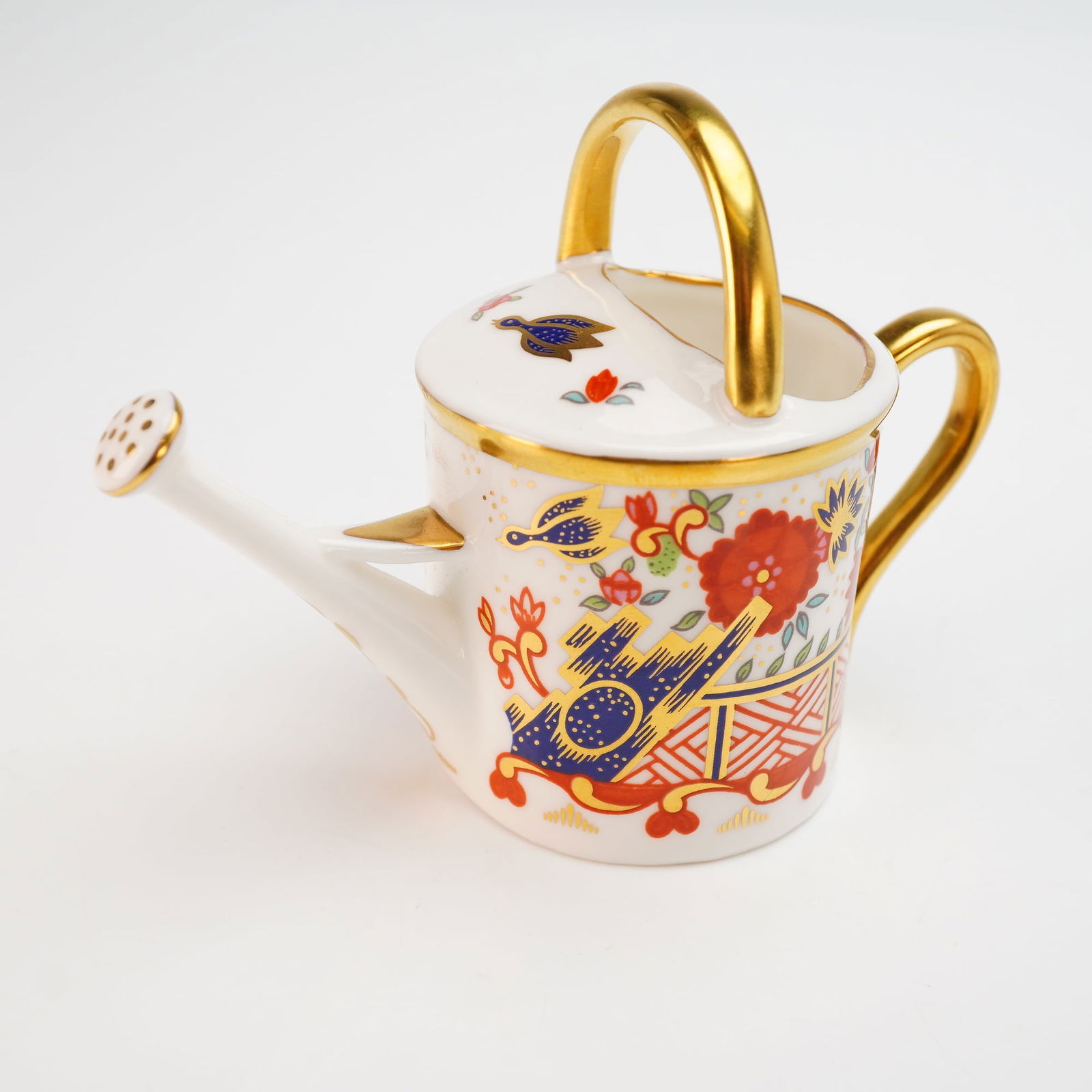 Royal Crown Derby Miniature Watering Can with Box: A Royal Crown Derby miniature watering can figurine crafted from English fine bone china in the Rich Japan pattern. The piece features an Imari-inspired palette of cobalt blue, iron red, and green,