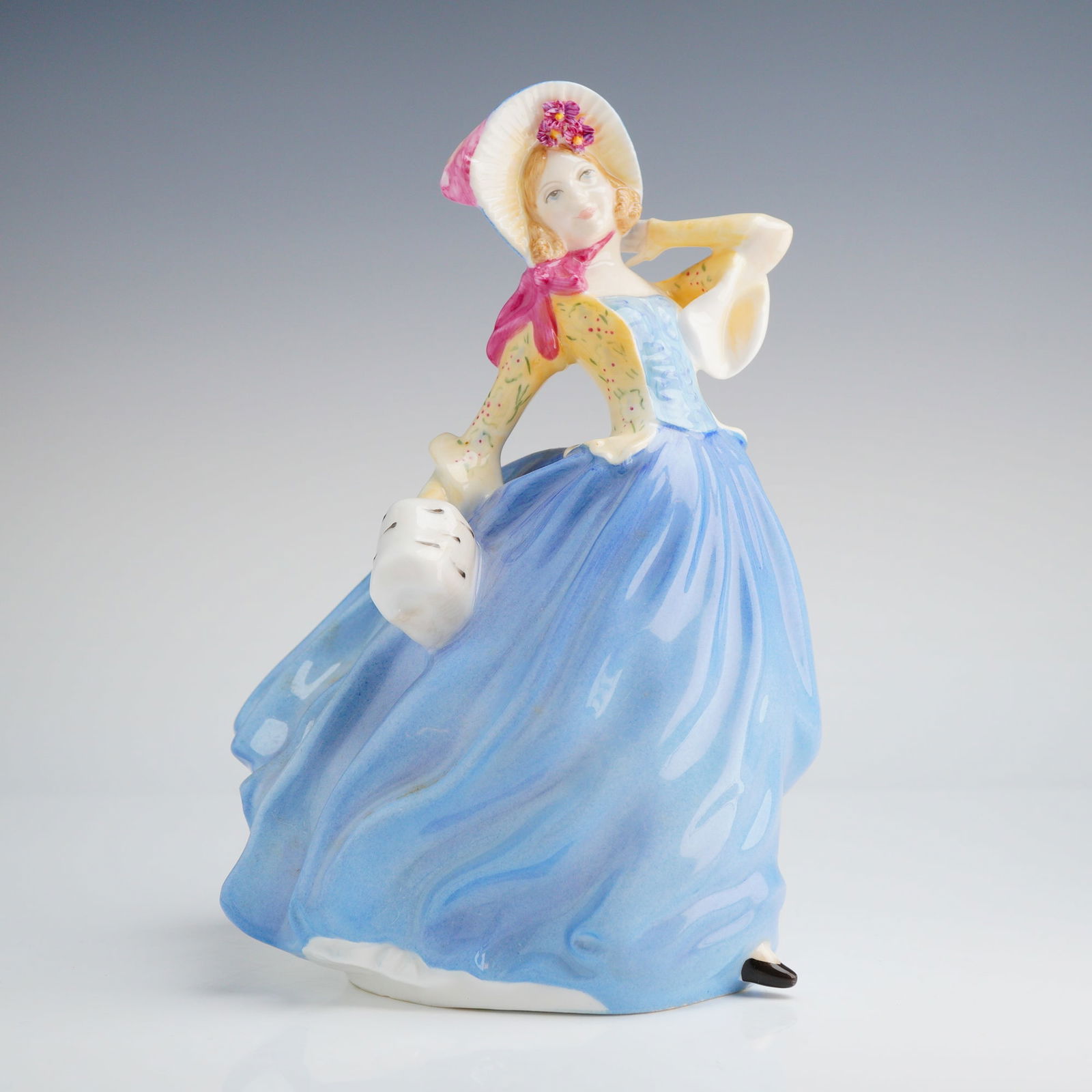 Royal Doulton Figurine, Autumn Breezes Blue HN 3736: A single Royal Doulton figurine depicting a woman, marked as a Michael Doulton Exclusive 1998 new colorway of the 1939 original design. Dimensions: 5.75"L x 8.00"H Weight: 1.40 lb