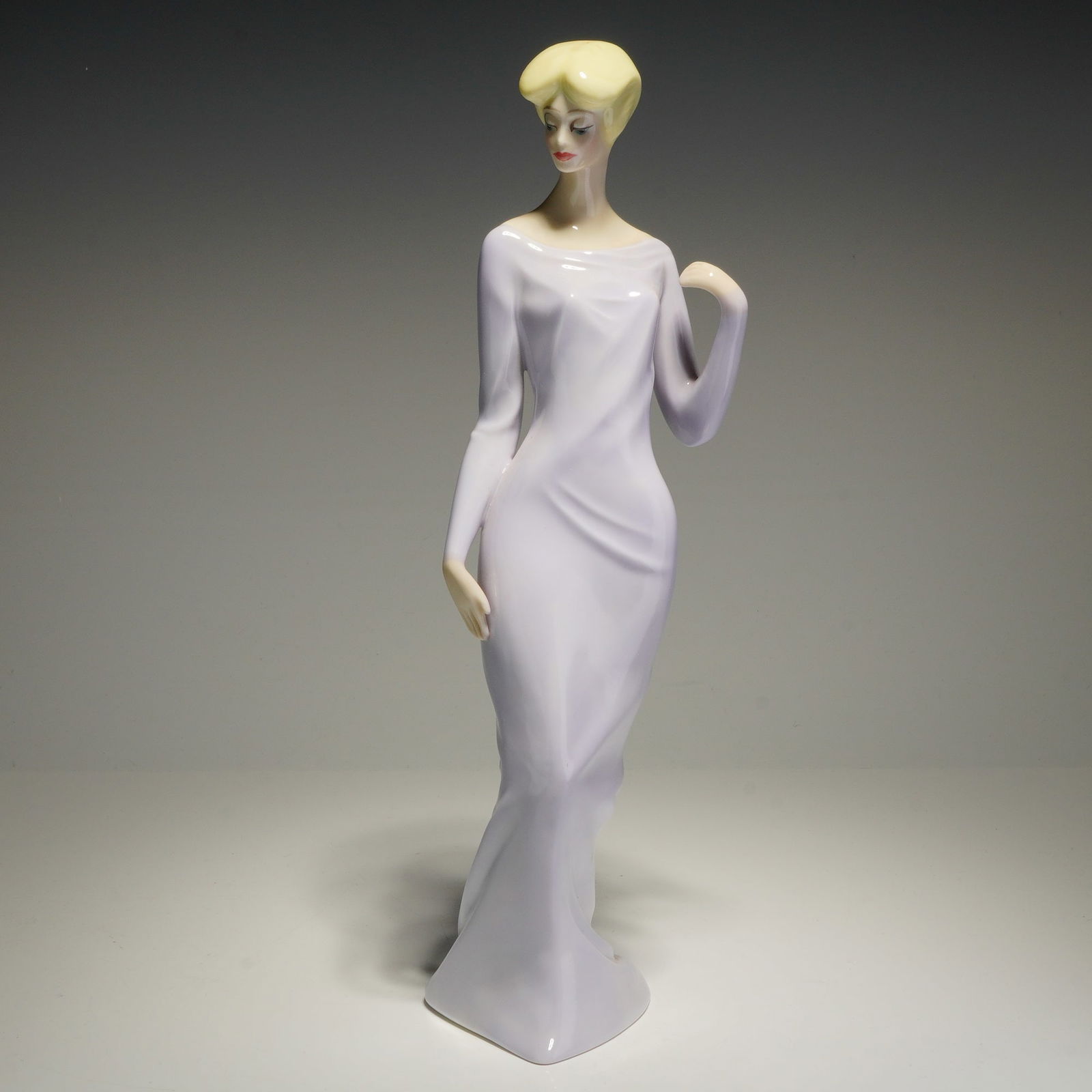 Royal Doulton Reflections Figurine, Debutante HN3188: This Royal Doulton glazed ceramic figurine, titled Debutante (HN 3188) from the Reflections series, was modeled by Eric J. Griffiths and is dated 1988. The figure depicts a stylized woman with blonde