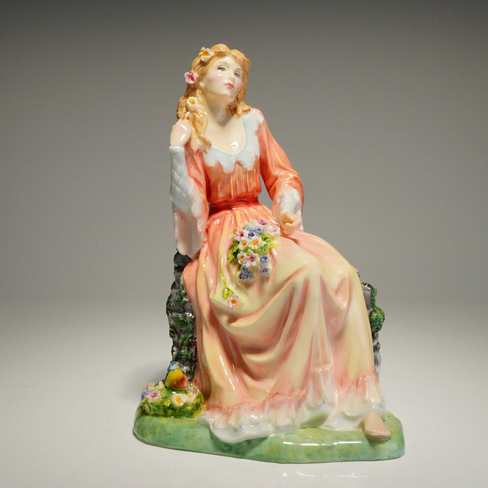 Royal Doulton Shakespeare Ladies Figurine, Ophelia HN3674: A Royal Doulton bone china figurine from the Shakespeare Ladies collection titled Ophelia, model number HN3674. This hand-painted piece depicts a seated young woman with blonde hair adorned with small