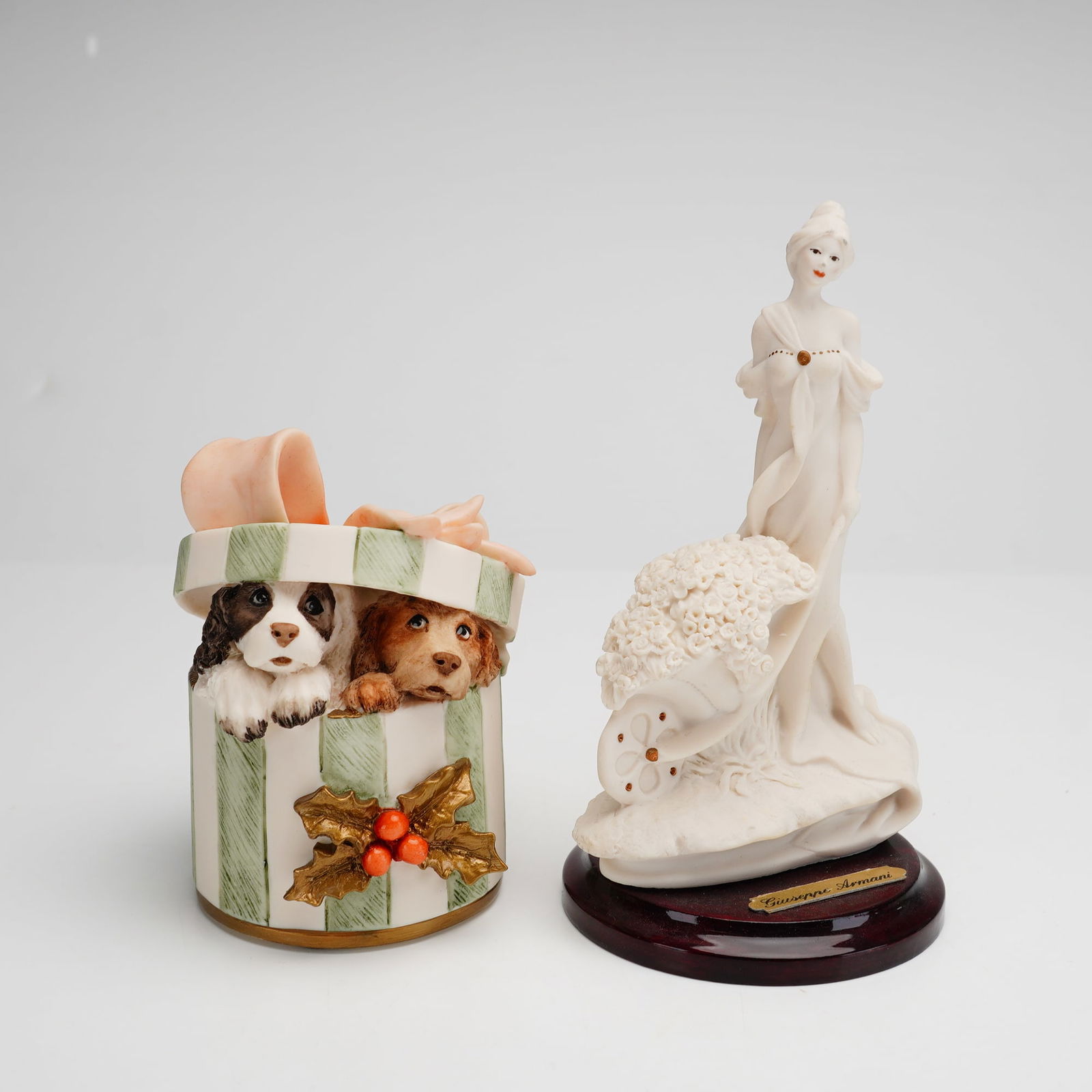 Two Giuseppe Armani Figurines, Xmas Surprise and Flowers for Sale: This lot consists of two figurines produced by Florence Sculture d'Arte and designed by Giuseppe Armani. The first piece is titled Xmas Surprise (model 1436C) and dated 1999, featuring a polychrome fi