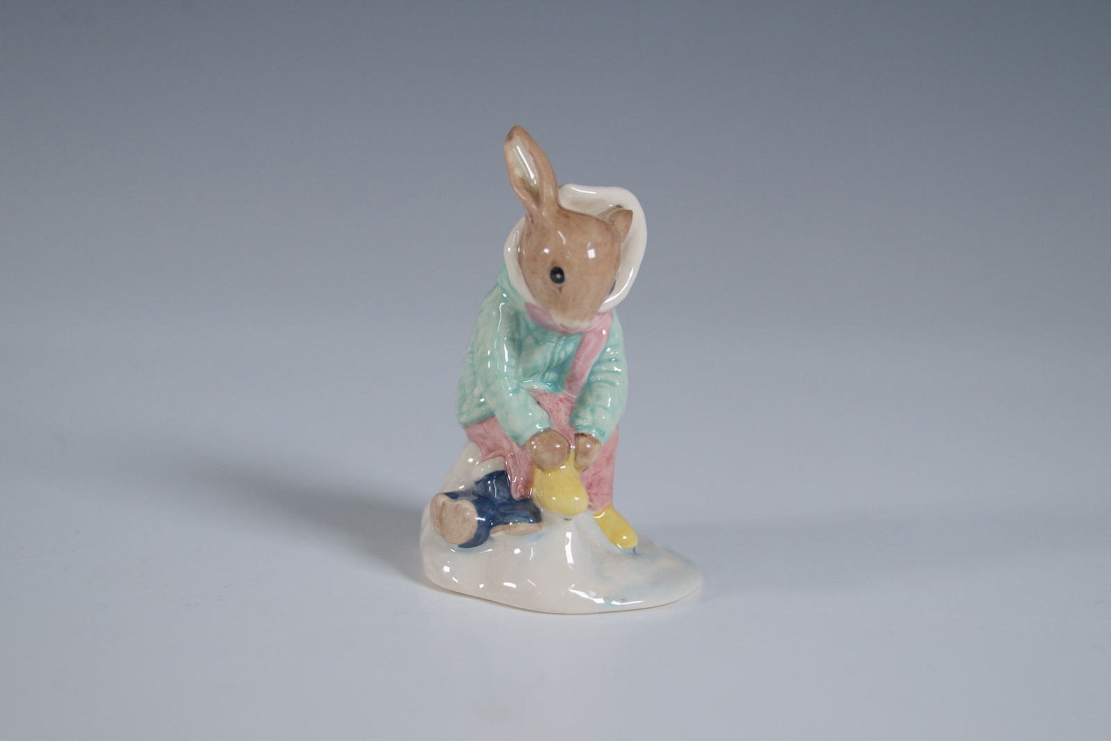 Royal Doulton Bunnykins Figurine, Girl Skater DB153: This delightful Royal Doulton Bunnykins figurine, titled "Girl Skater Bunnykins" (DB153), depicts a bunny dressed in a charming winter outfit, skating gracefully. The figurine stands 3.5"H and is in