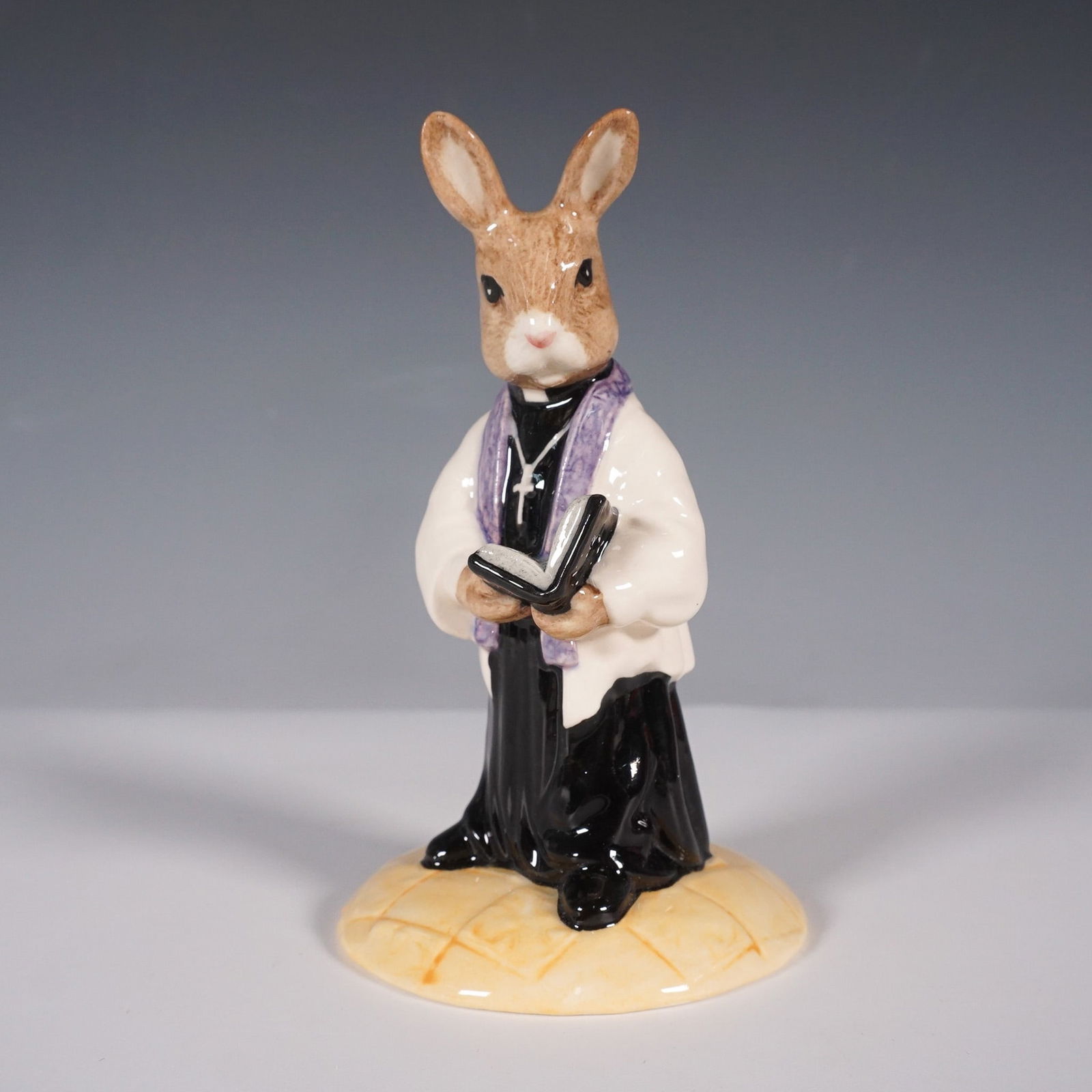 Royal Doulton Bunnykins Figurine, Vicar DB254: This finely crafted figurine was issued exclusively for the Royal Doulton International Collectors Club in 2002. It portrays a dignified vicar rabbit in a traditional black cassock, complemented by a