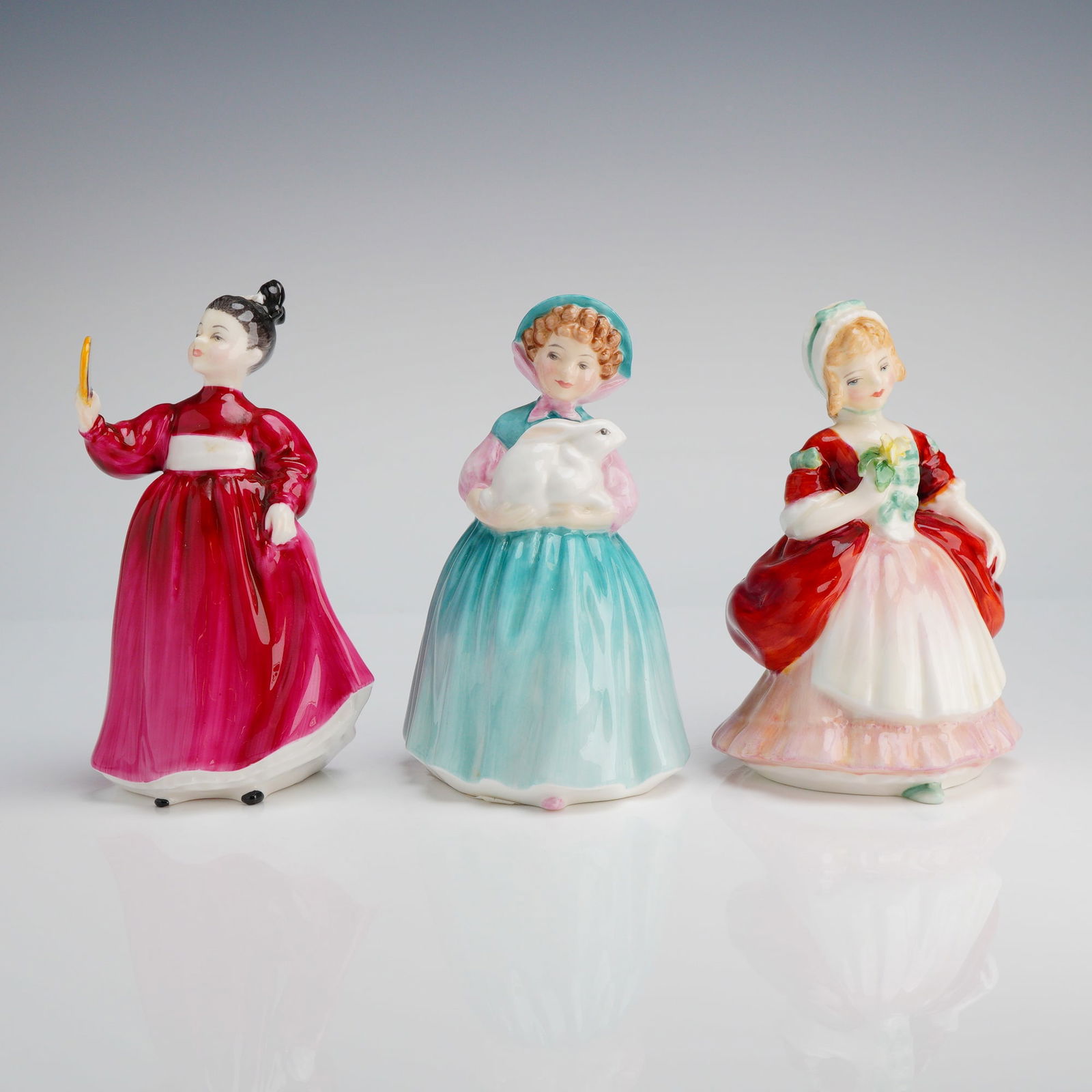 3pc Royal Doulton Figurines, Bunny HN2214, Valerie HN2107 & Vanity HN2475: Three Royal Doulton figurines designed in colorful period dress, one holding a flower, another a rabbit and the last a mirror. All marked ROYAL DOULTON, MADE IN ENGLAND, and "Potted by DOULTON & CO LI