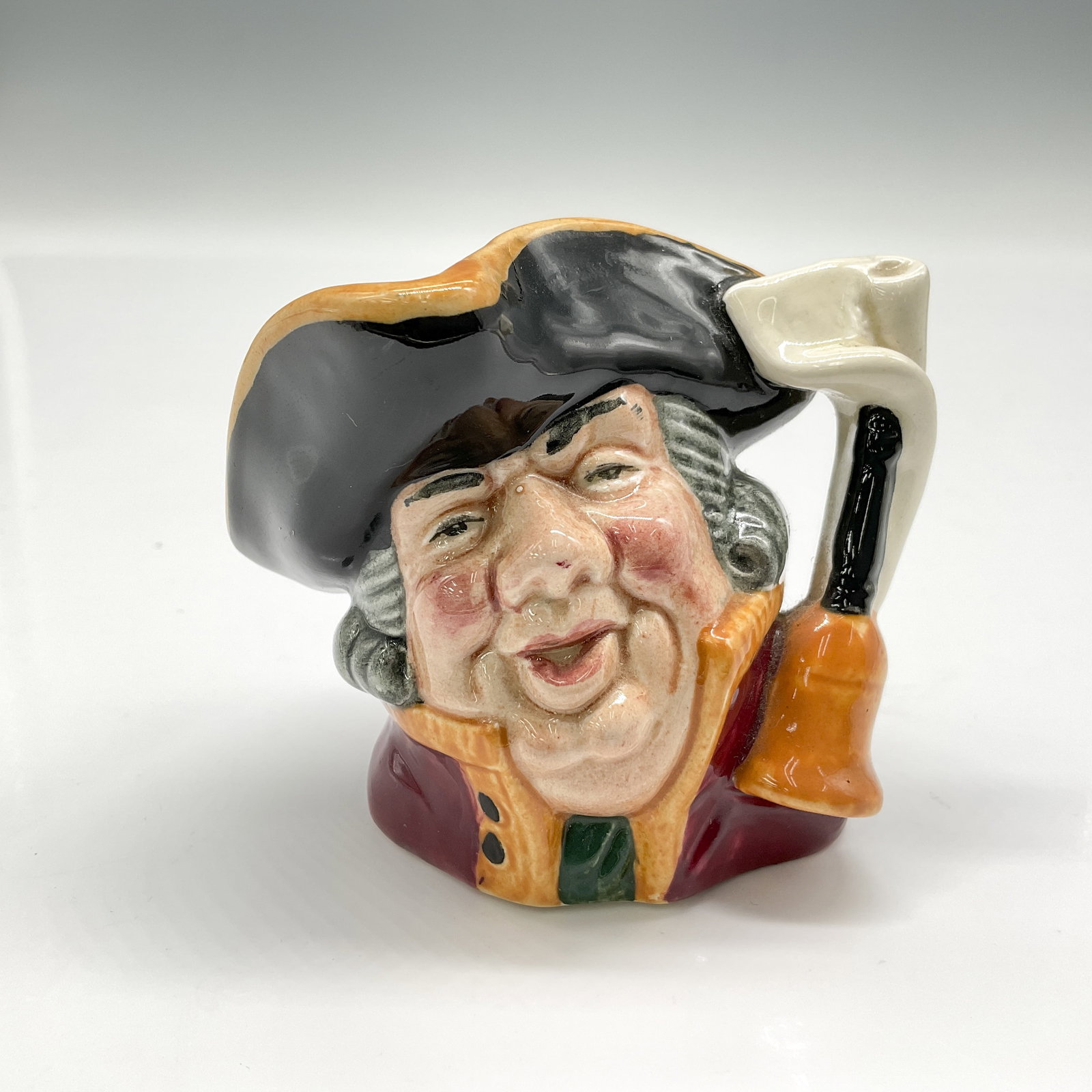 Town Crier D6544 - Mini - Royal Doulton Character Jug: Style One, bell on scroll. Black hat trimmed with gold; scarlet coat trimmed with gold. Royal Doulton backstamp. ArtistDavid B. Biggs Dimensions2.5"H Date or Era1960 - 1973 Manufacturer or BrandRoyal