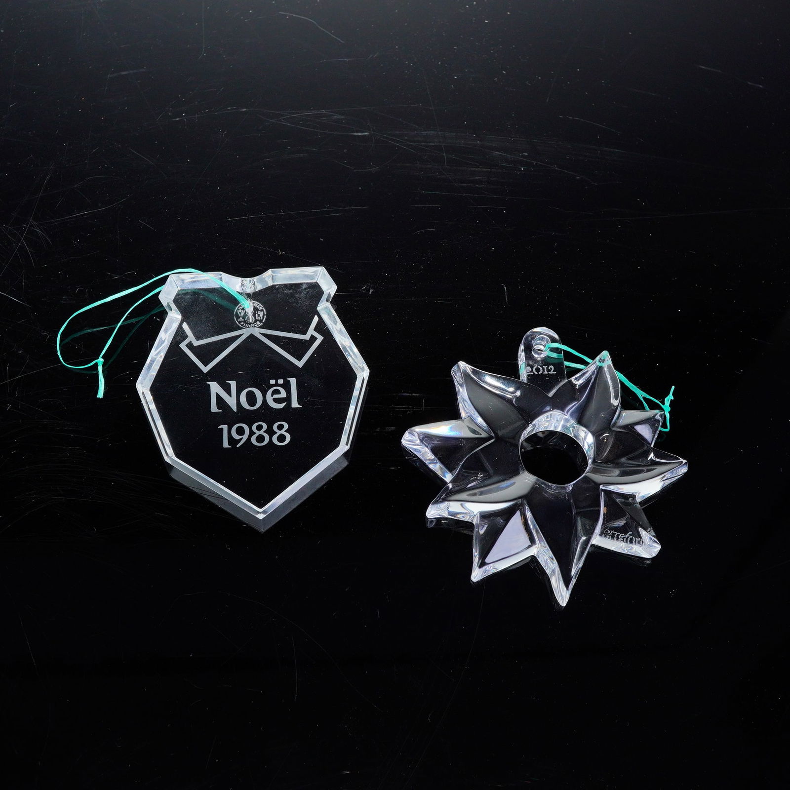 2pc Baccarat and Orrefors Crystal Annual Christmas Ornaments, 1988 & 2012: This lot features a 2'piece collection of fine crystal Christmas ornaments from two renowned makers: Baccarat and Orrefors. Included is a 1988 Baccarat Noel ornament, showcasing the brand's signature