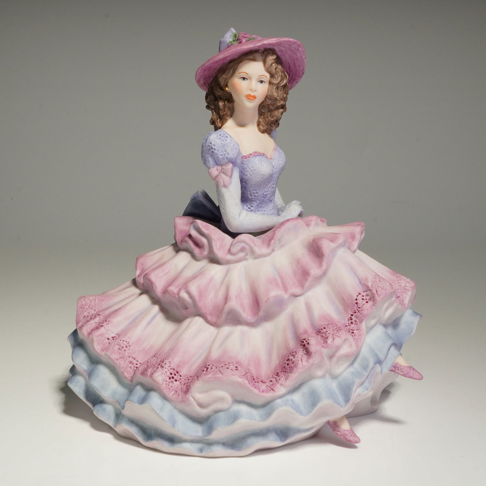 Coalport Porcelain The Age of Elegance Figurine, Covent Garden: This fine porcelain figurine is titled Covent Garden from The Age of Elegance collection. Manufactured in England and dated 1992, the hand-painted figure depicts a seated woman in Victorian-style dres