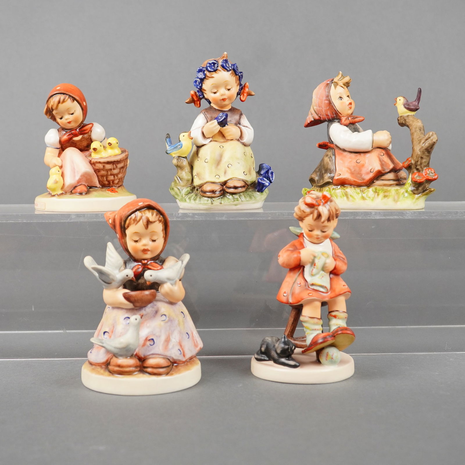 5 Goebel Hummel Figurines incl. Cinderella: A collection of five (5) glazed porcelain figurines executed in the M. I. Hummel style, manufactured by Goebel. The 5pc Goebel Hummel Figurines depict children in various folk settings, characterized