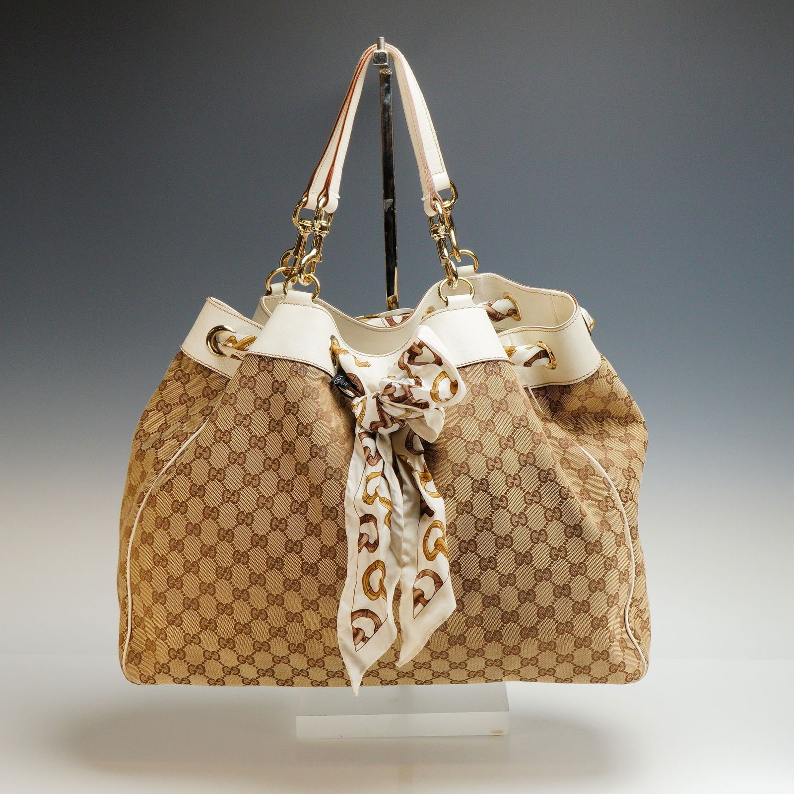 Gucci Positano Scarf Tote Bag in Beige GG Canvas and White Leather Trim: Gucci Positano Scarf Tote Bag crafted in the house's signature beige GG canvas with crisp white leather trim, offering a refined balance of casual elegance and iconic branding. This spacious tote feat