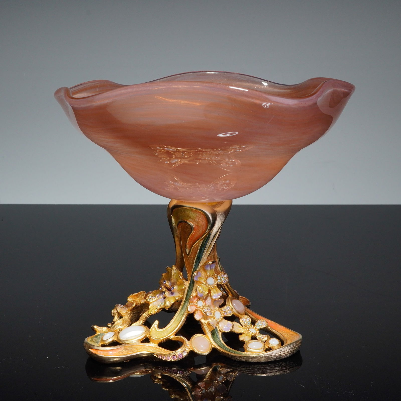 Jay Strongwater Pedestal Flower Bowl with Pearlescent Accents: Decorative dish with pearlescent accents, featuring a hand-blown glass vessel with a ruffled rim and a marbled peach and apricot finish. The bowl is supported by a gilded metal pedestal base cast with