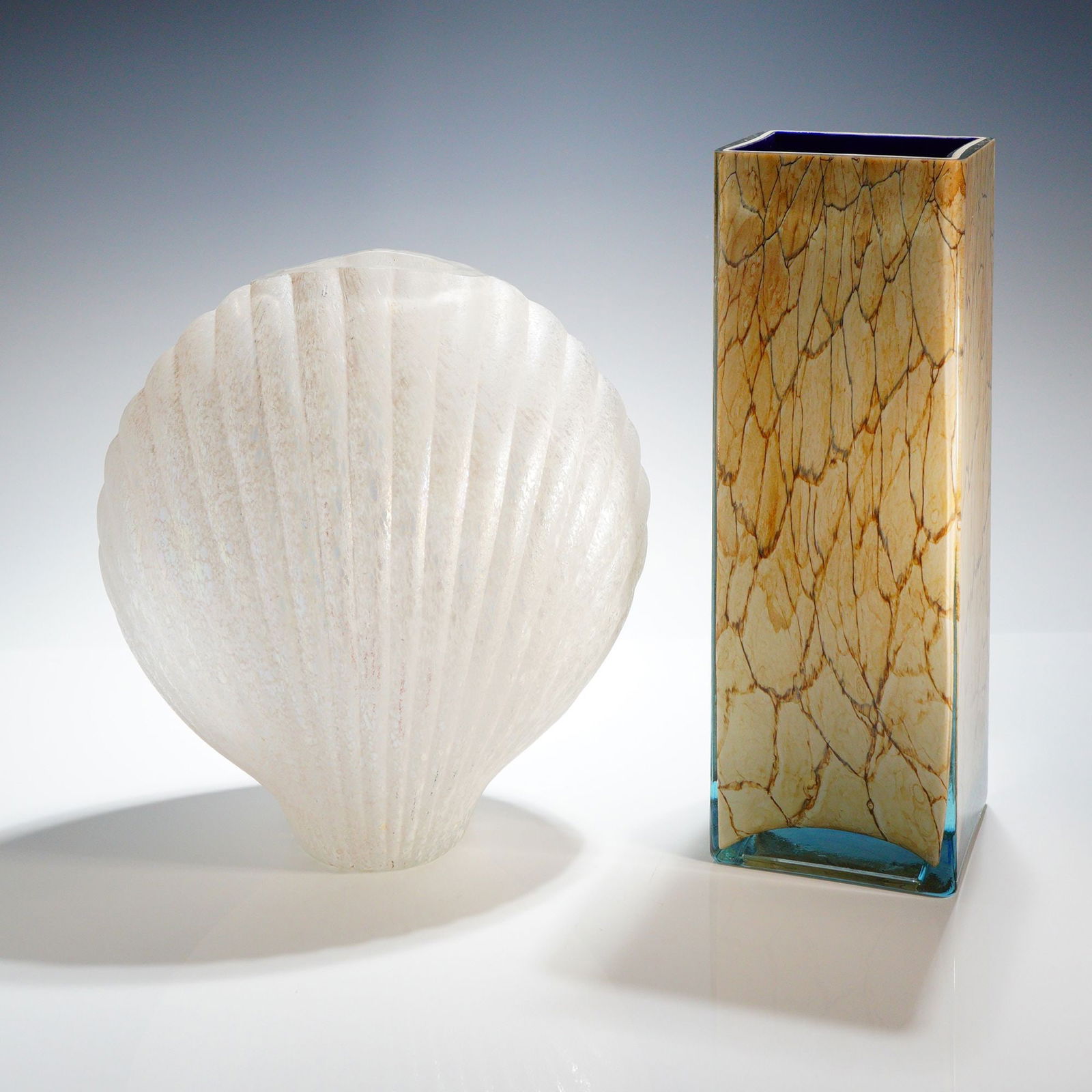 2 Art Glass Vases Silvestri Shell Form & Style of Jozefina Krosno Poland: A collection of two pieces of contemporary art glass with one tall, rectangular vase in the style of Jozefina Krosno, Poland. The vase is constructed from layered glass, featuring a dark navy blue int