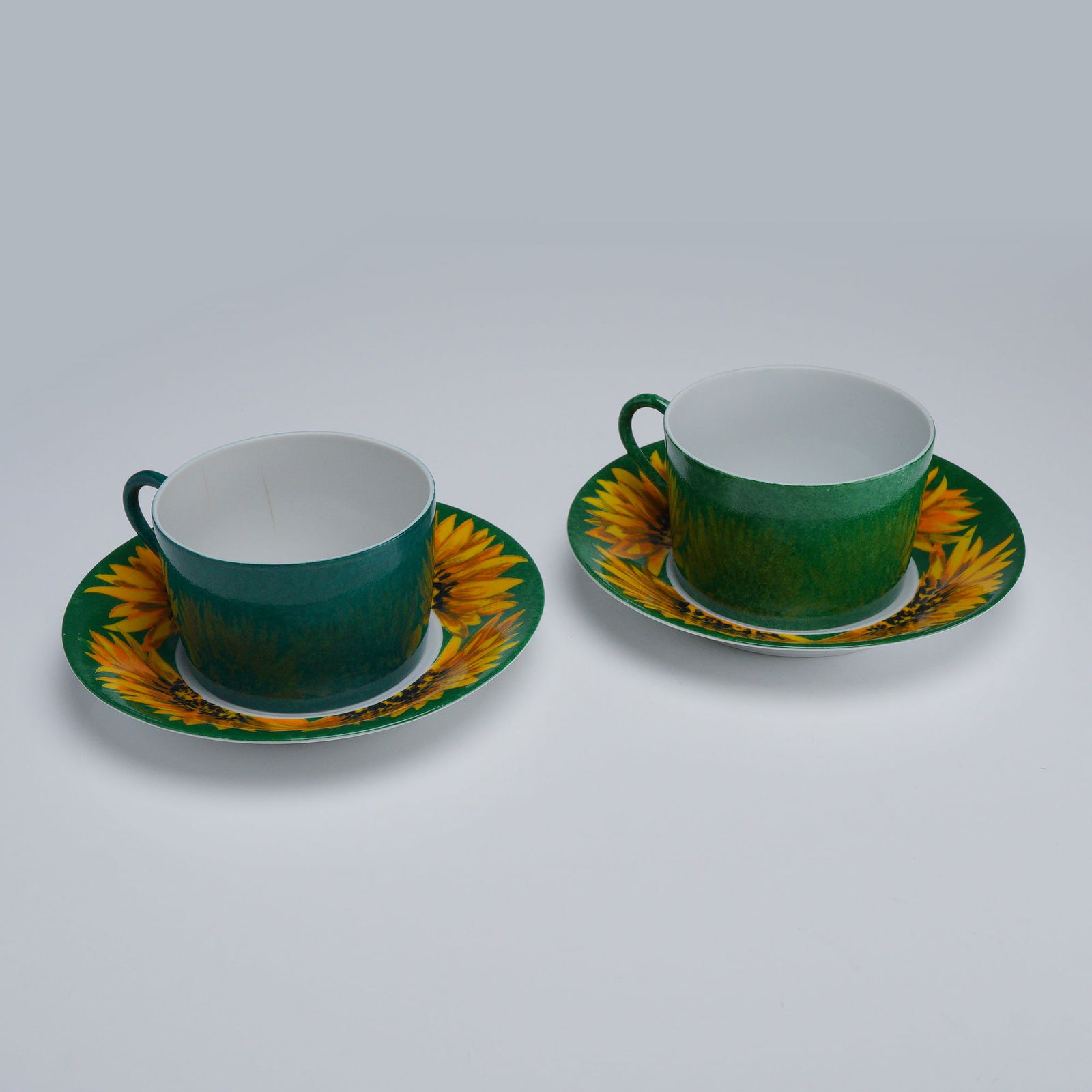 4pc Laure Japy, Made in Limoges for Barney's New York, Teacups & Saucers: Features two sets of Laure Japy teacups with matching saucers, decorated in a vibrant sunflower motif against a Tournesol green background on the saucers. The cups are finished in a Tournesol green. M