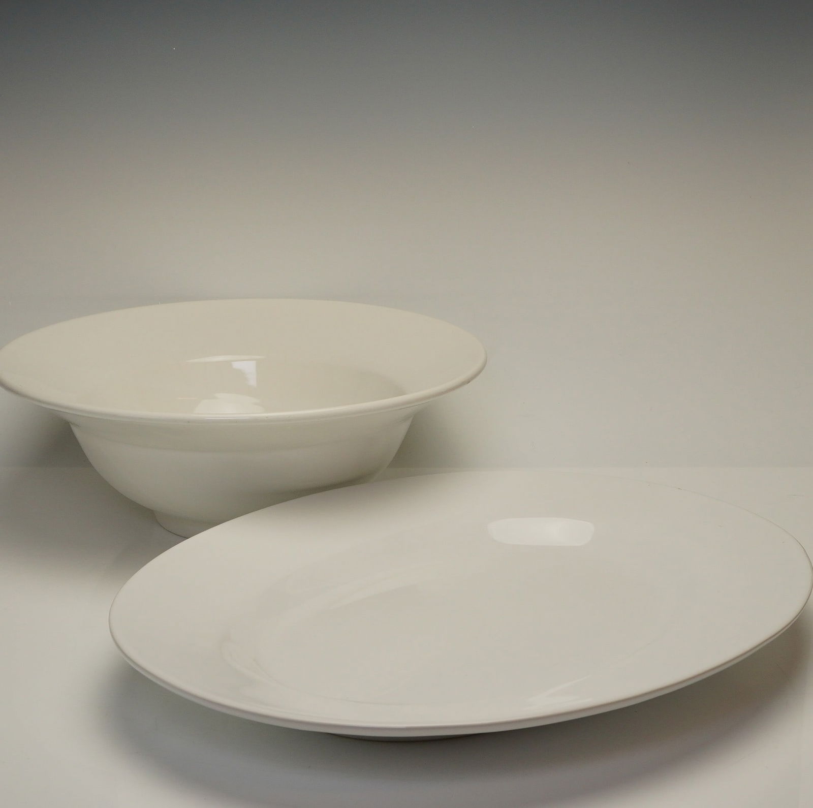 2pc The Cellar Italy & ASA Germany White Serving Platter and Bowl: The large serving bowl is from The Cellar and was made in Italy. The piece is constructed with a wide, flared rim and sits on a slightly raised foot. The underside of the bowl is marked with a stamp r
