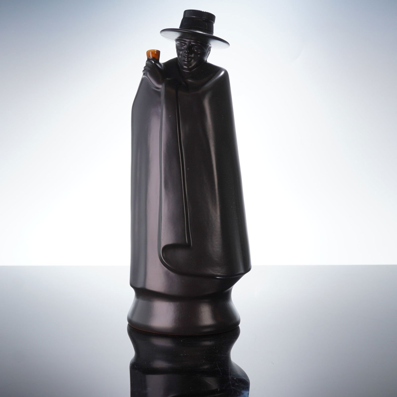 Sandeman Armada Cream Sherry in a Wedgwood Don Decanter: A vintage Wedgwood Sandeman figure decanter produced for Sandeman Armada Cream Sherry. This figural Wedgwood Don Sandeman sherry decanter is crafted from matte black ceramic, modeled after the company