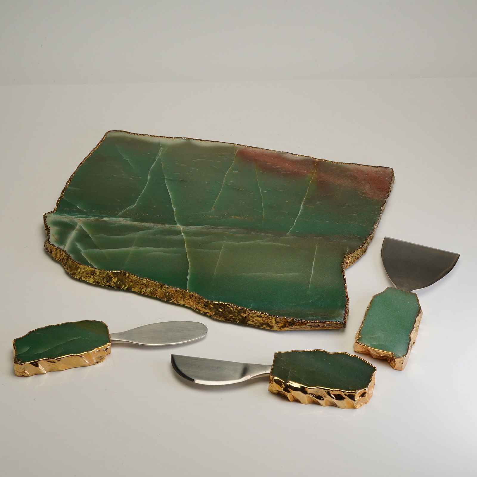 ANNA by RabLabs Kiva Cheese Utensils and Cutting Board: This set is crafted from green quartz and features 24K gold handles and borders. The collection consists of a large slab and three coordinating cheese tools with brushed stainless-steel blades. Each c