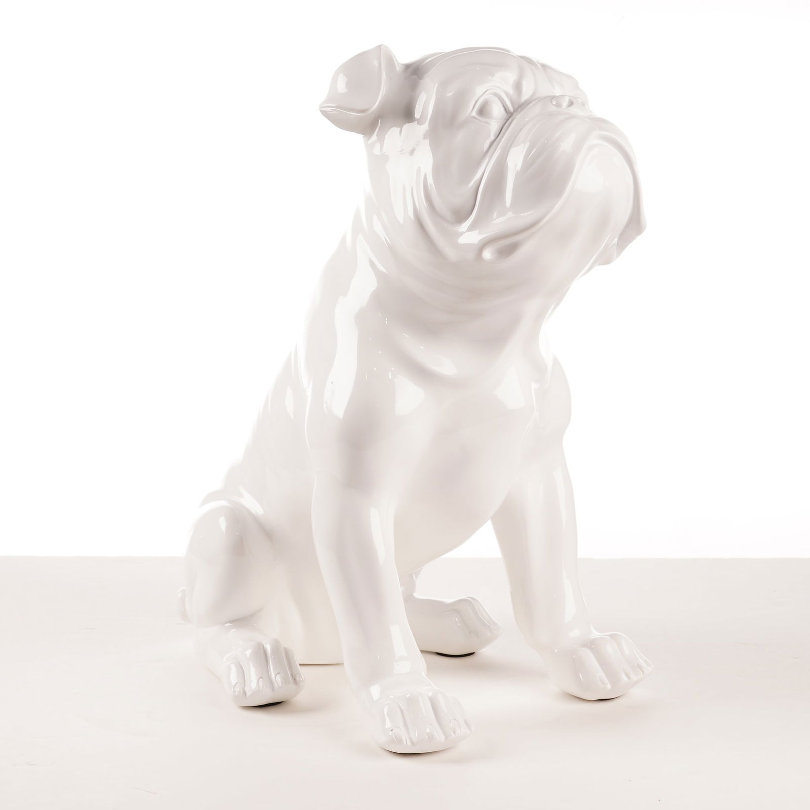 Z Gallerie Glossy White Ceramic English Bulldog Sculpture: A contemporary glossy white ceramic sculpture of an English bulldog depicted in a seated posture with the head slightly upturned. The sculpture incorporates characteristic breed features including a w