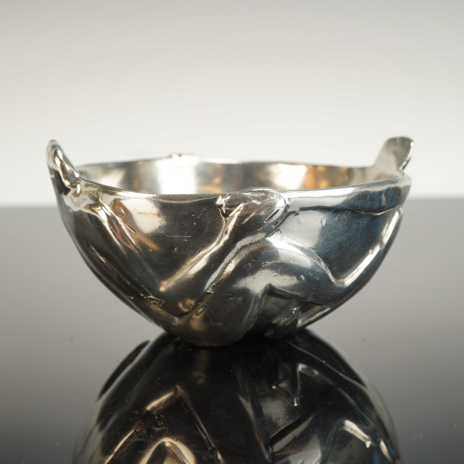 Carol Boyes Figural Pewter Bowl: Sculptural bowl is designed with two human forms with intertwined fingers. Boyes impressed mark on base. Dimensions: 6"L x 5.5"W x 3"H Country of Origin: South Africa Weight: 1.10 lbs.