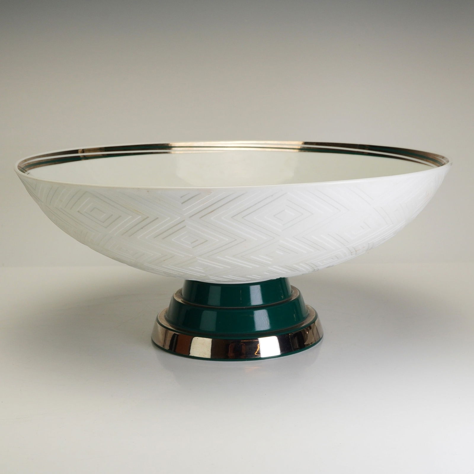 Vista Alegre Porcelain Centerpiece Bowl, Lavish: The piece features a shallow white basin with a textured geometric diamond pattern on the exterior. The bowl is supported by a dark green pedestal base accented with a broad metallic silver-toned