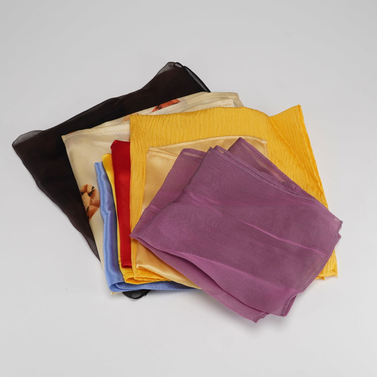 9pc Silk Handkerchief Collection: This lot consists of nine vintage handkerchiefs in assorted colors and materials. The group includes solid shades of red, yellow, blue, purple, and gold along with several patterned pieces including o