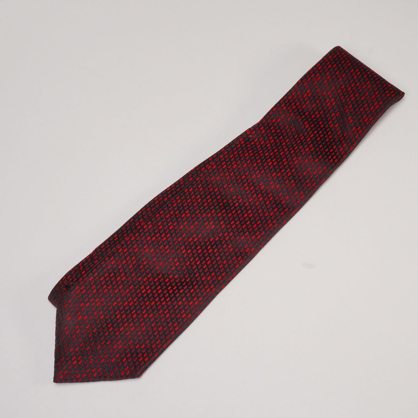 Hilditch & Key for Saks Fifth Avenue Silk Tie: A Hilditch & Key for Saks Fifth Avenue silk tie featuring a woven geometric pattern in red and black. The design consists of a subtle grid motif giving a textured appearance. The tie is lined in pale