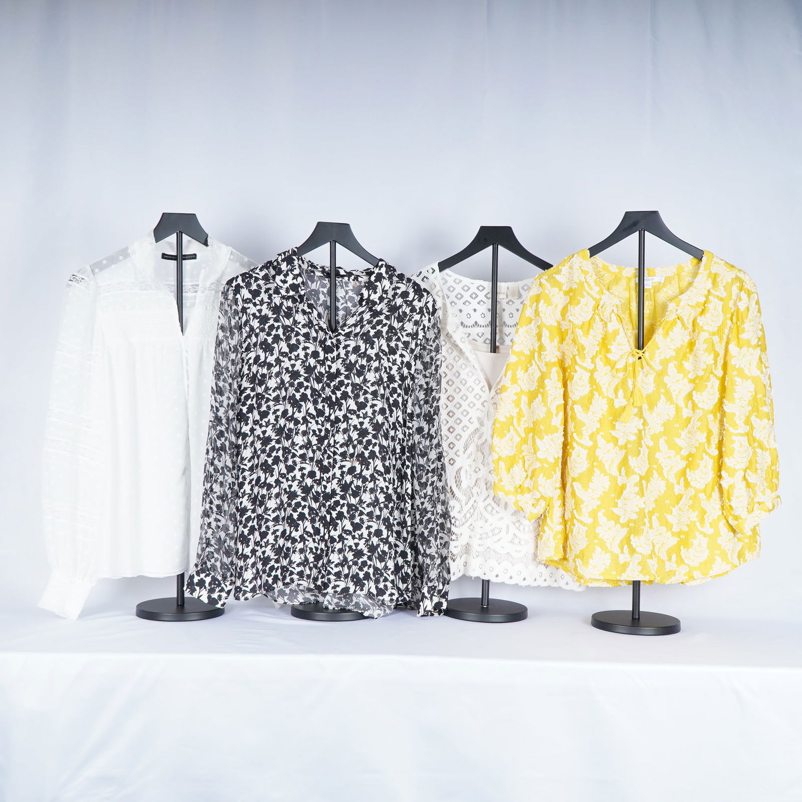 4pc Chico's, Tahari, & White-Black Women's Blouse Assortment: Women's blouses including styles by Chico's, Tahari, and White House Black Market. The grouping features a textured white blouse with subtle dot detailing (Tahari), a sheer black-and-white floral